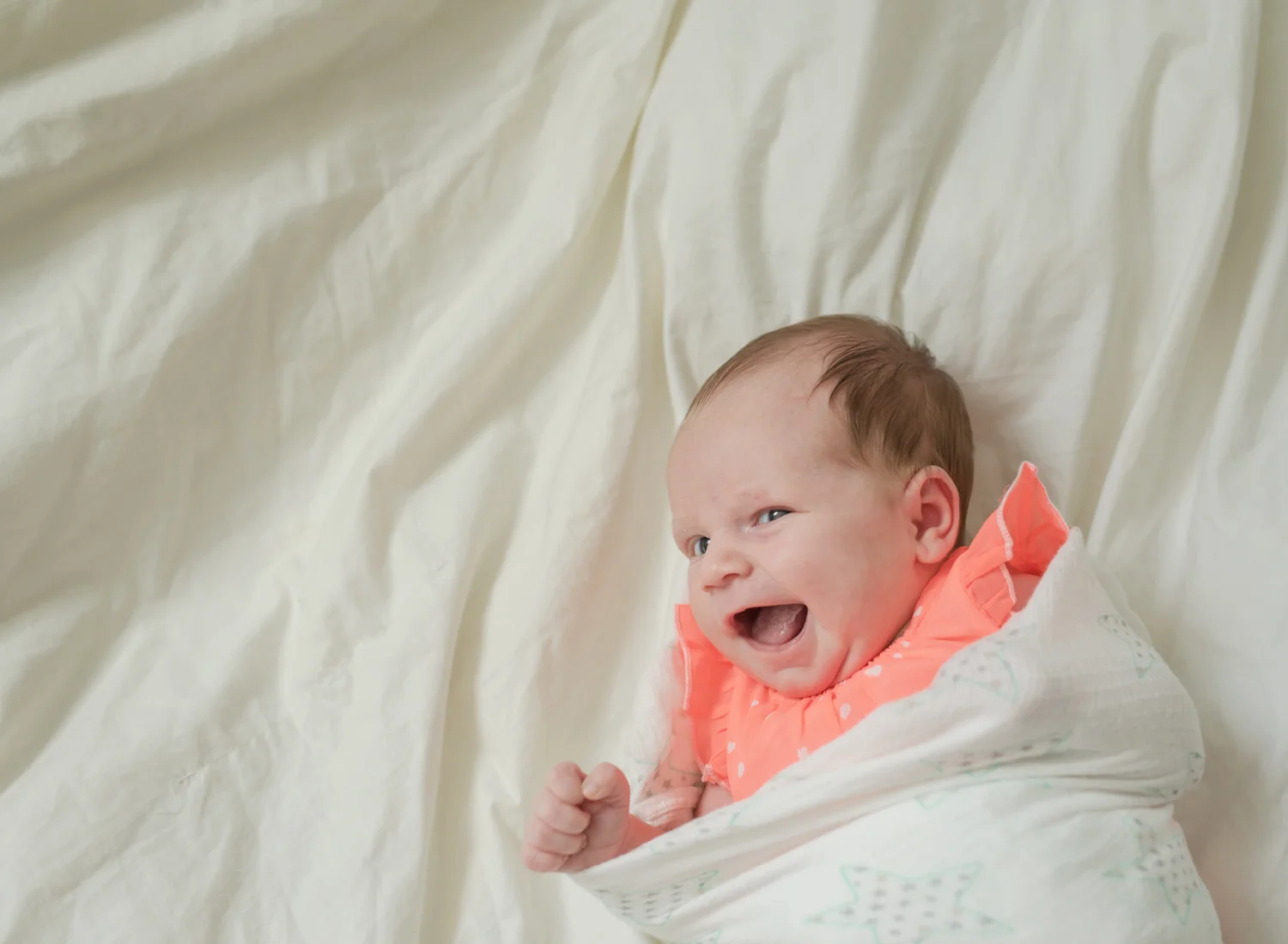 Newborn baby girl with a huge smile on her face in studio Fargo, ND.