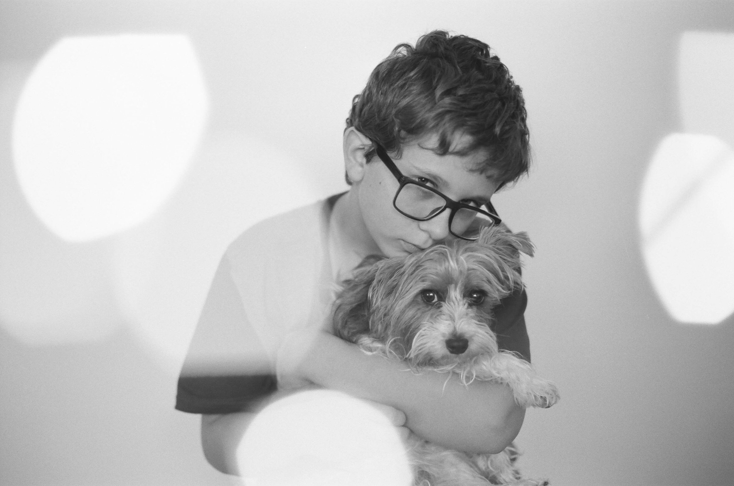 A young boy hugging his Yorkie puppy in a studio session Fargo.