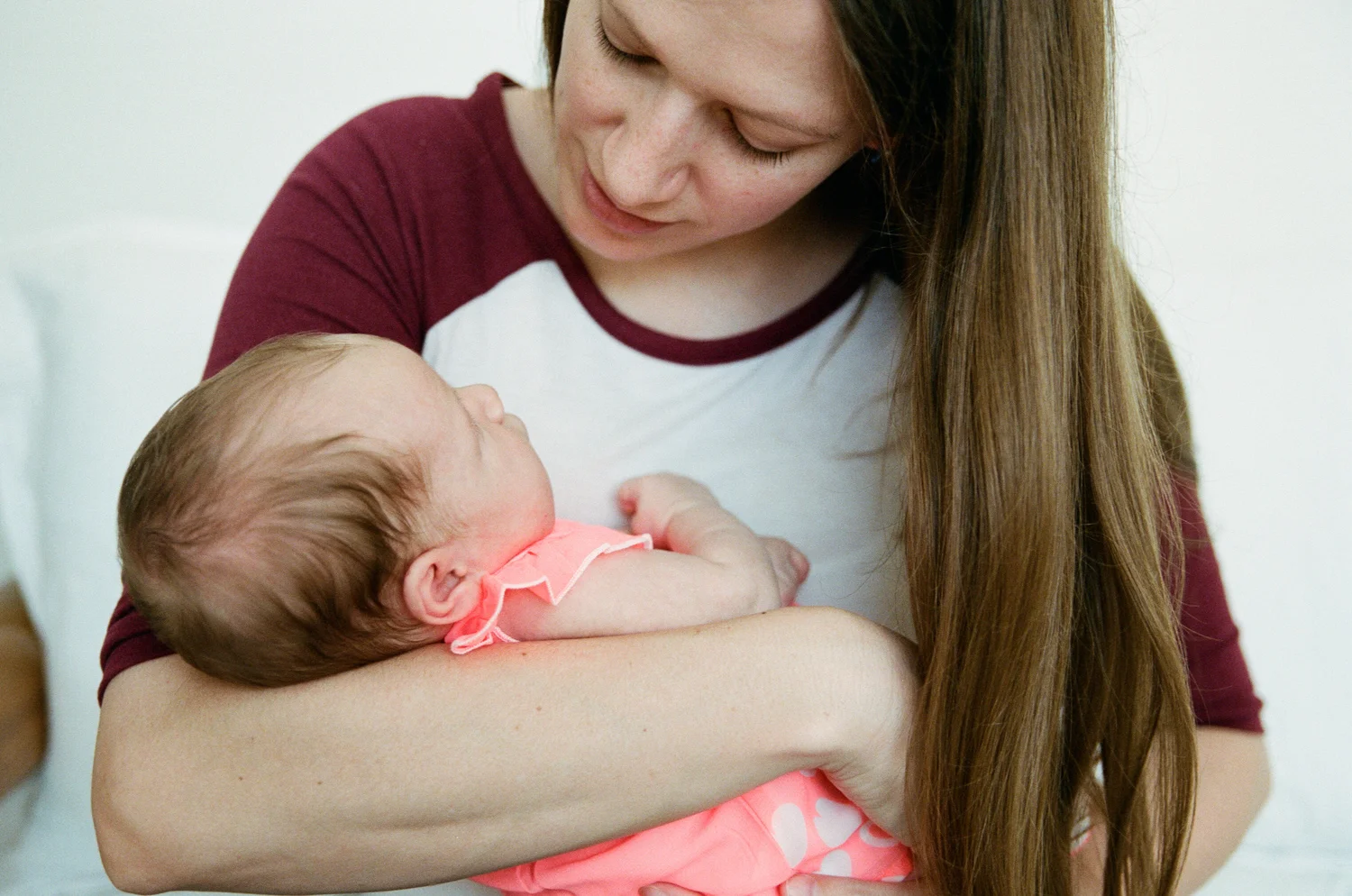 Mom holding her newborn and gazing into her eyes during a newborn session in Fargo.