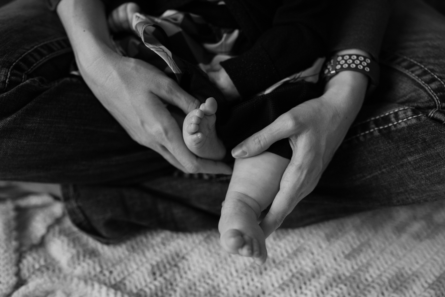Detail shot of a six month old's mom holding her babies feet.