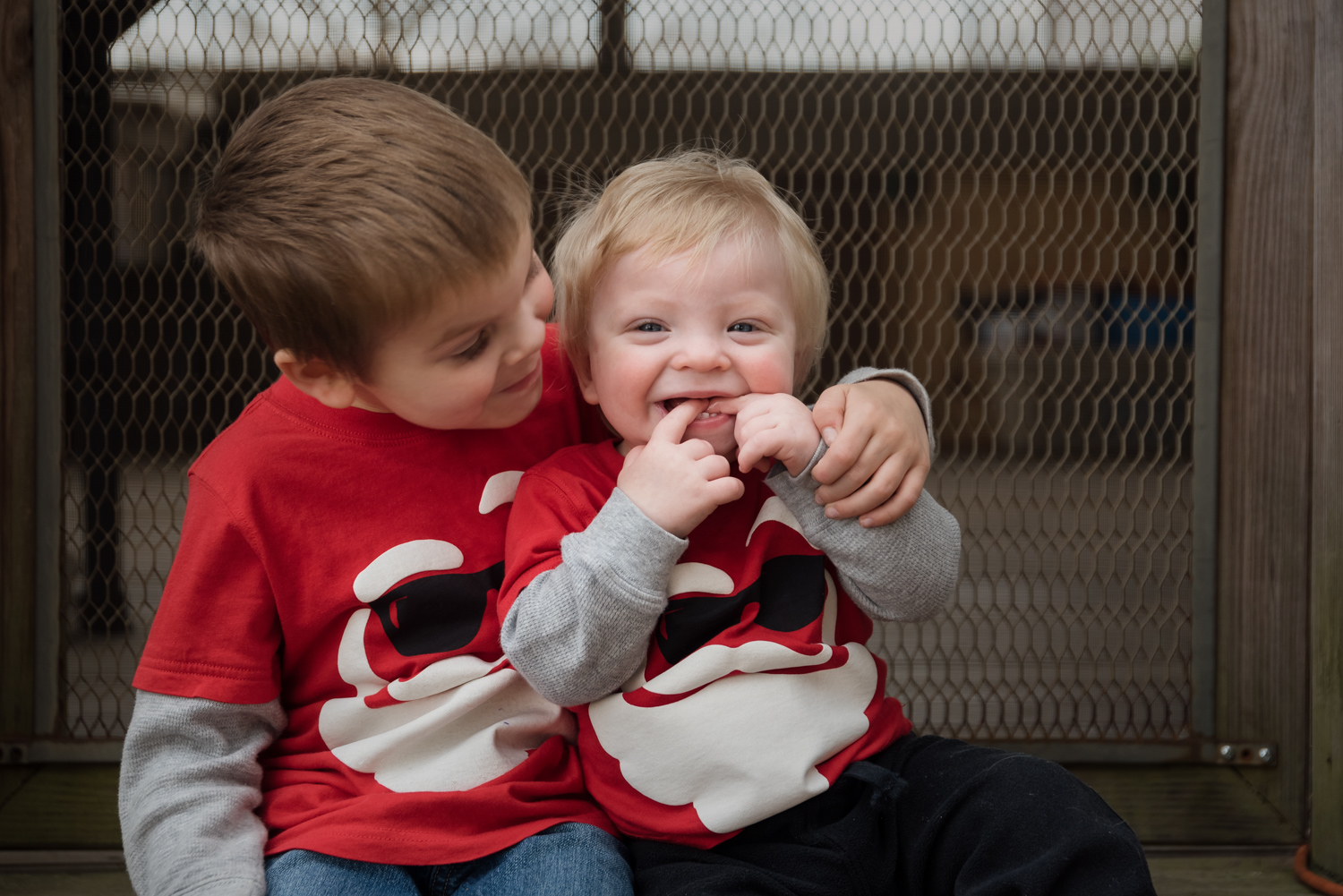 Boys sittling on the back step of a home having their portrait taken.