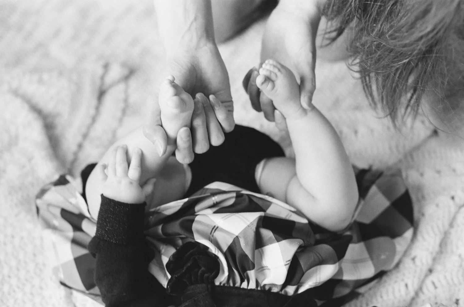 Image of a mom holding her babies feet.