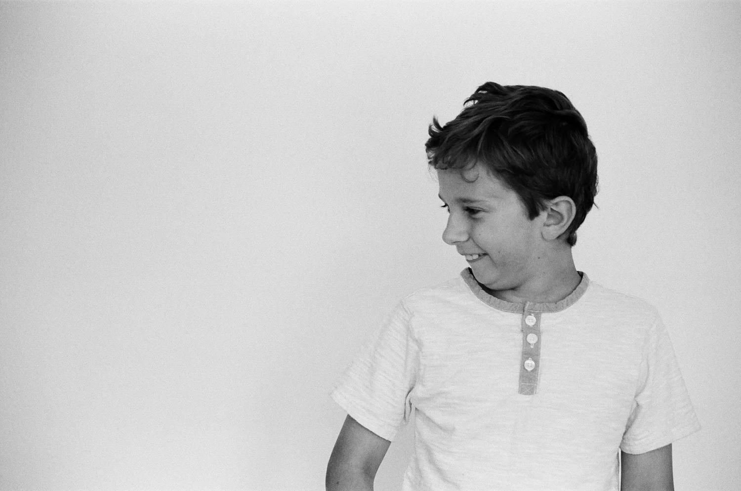 Profile portrait of a boy smiling and being silly.