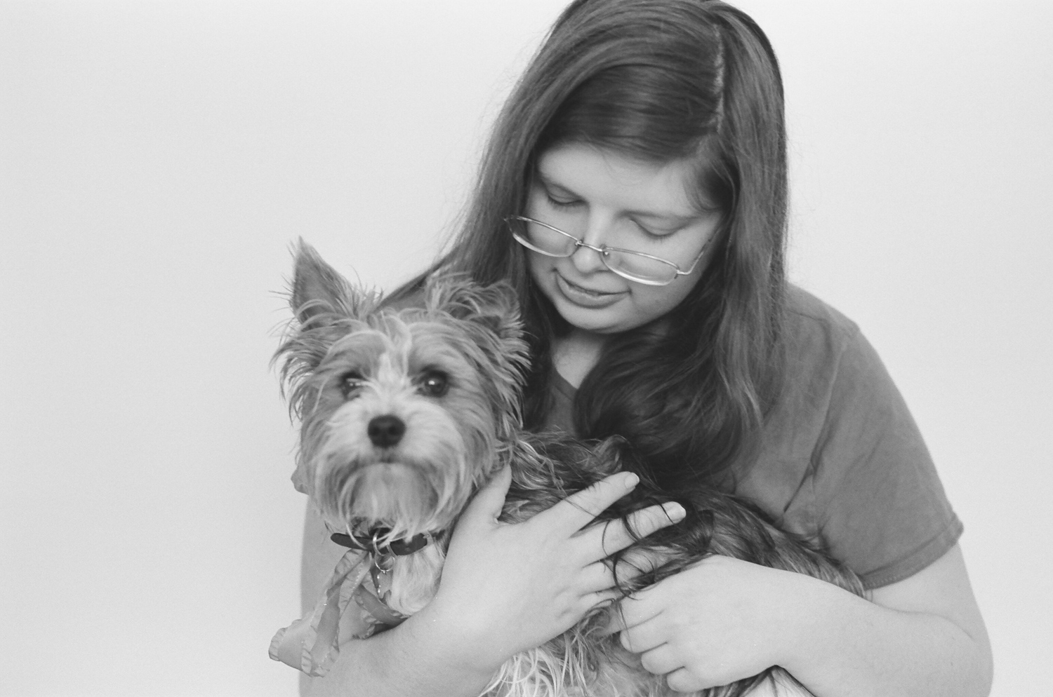 Portrait of a girl holding her yorkie dog on her lap.