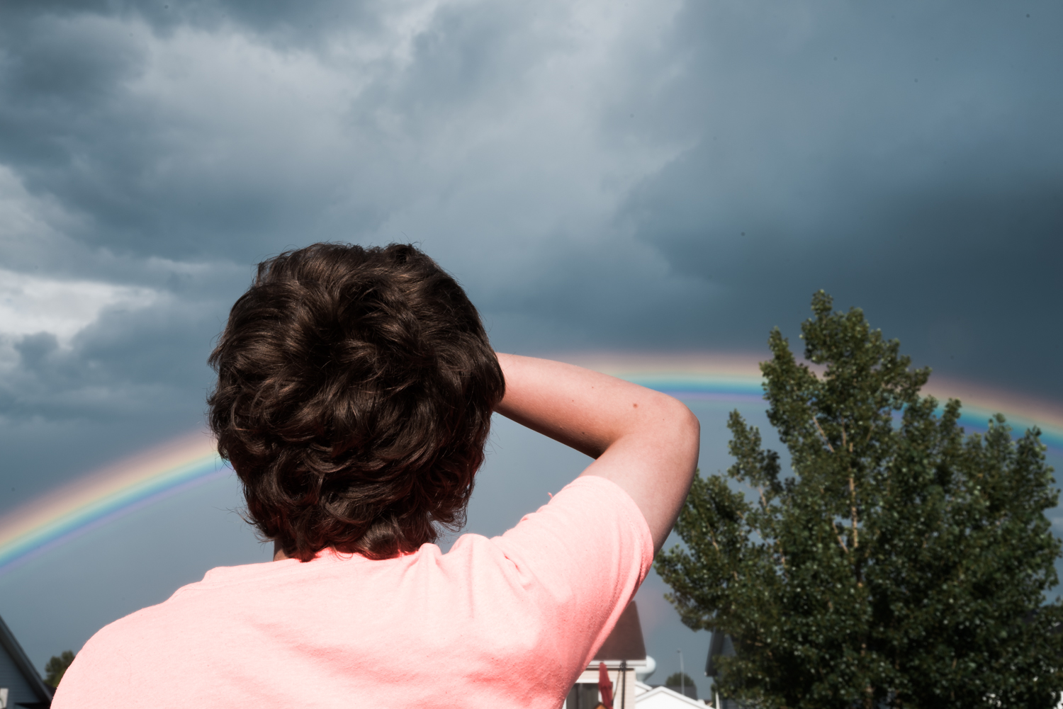 Boy looking at a rainbow.