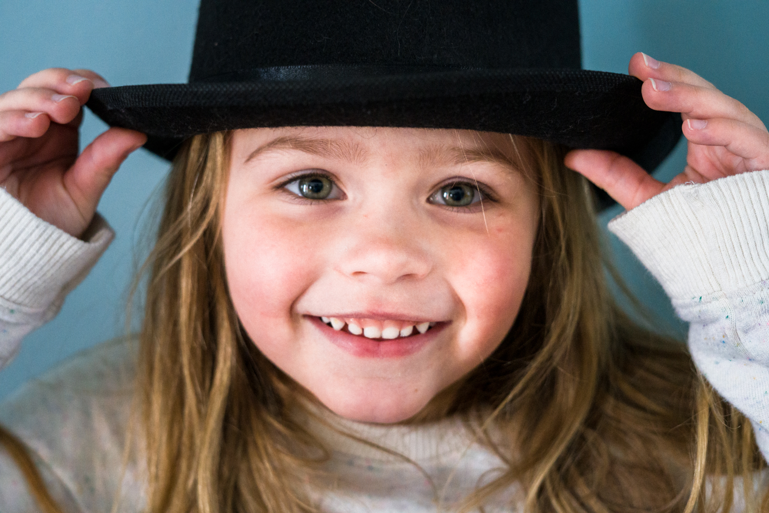 Portrait of a girl wearing a hat during dramactic play and smiling at daycare in Fargo.