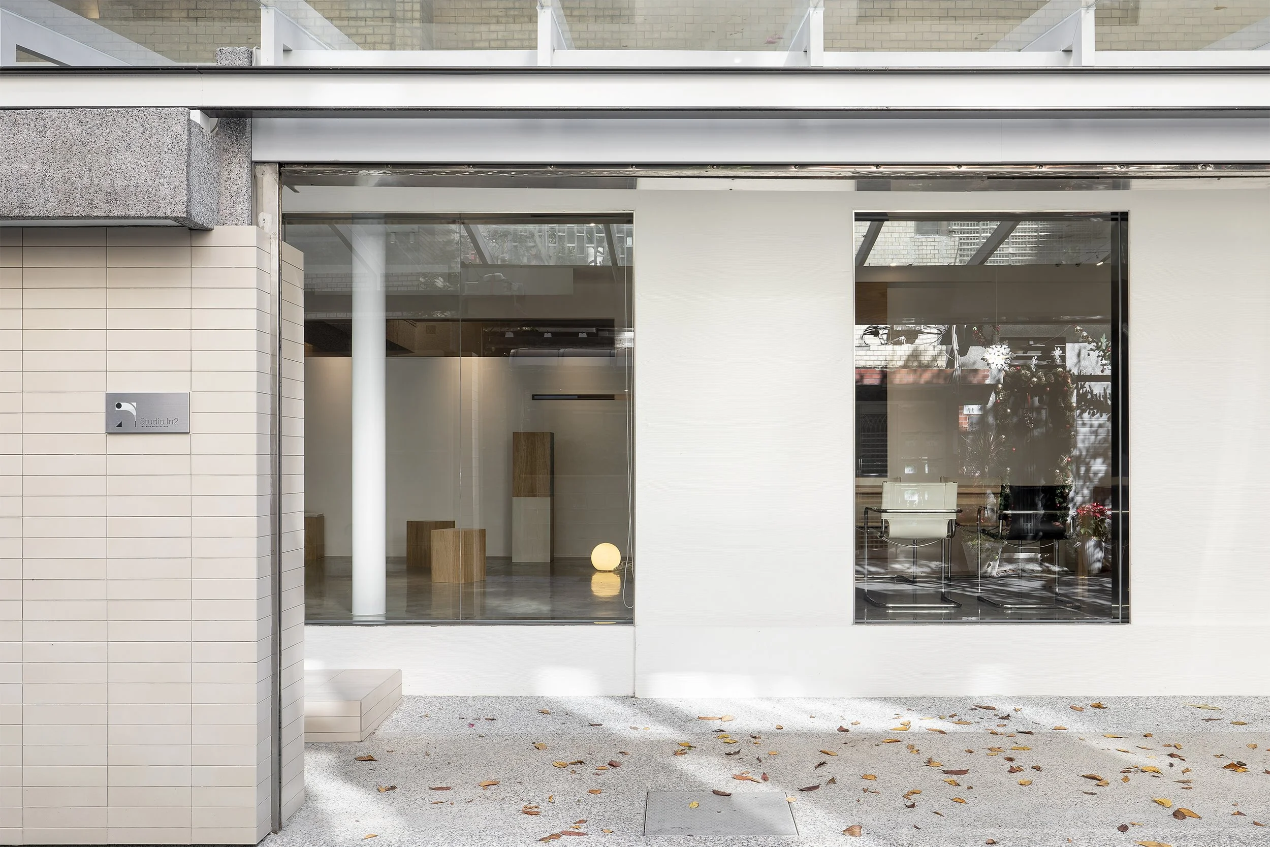 Studio In2 辦公室空間，台北室內設計，以白色量體、大面玻璃與既有建築結構，打造簡約而具建築感的工作空間。Studio In2 Xingshen office interior architecture in Taipei.
