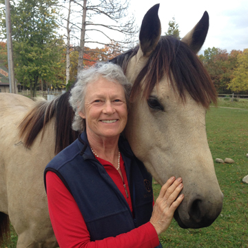 Dr. Arwin at home with her buckskin quarter horse Bobby Socks.