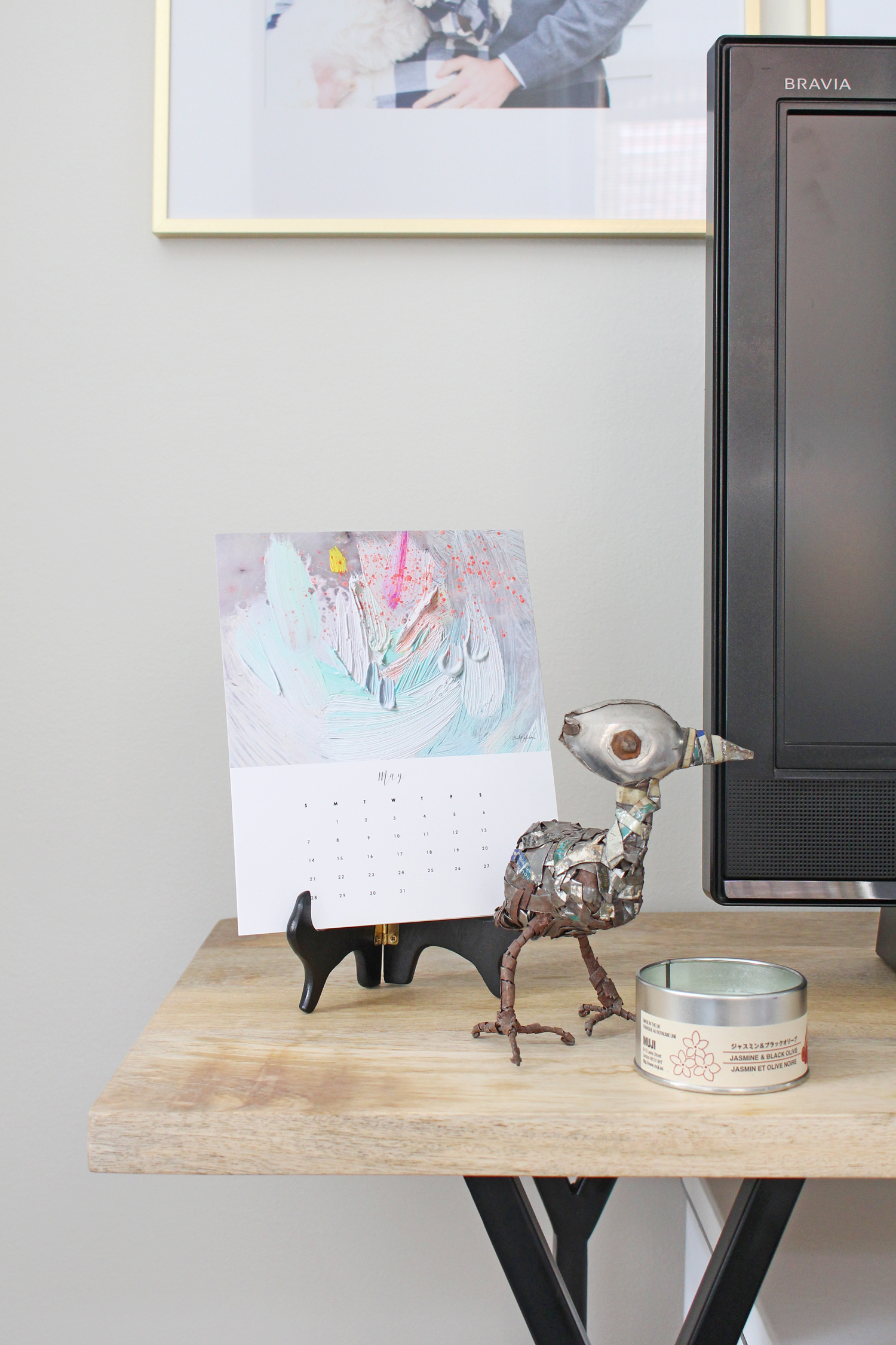A calendar from Emily Jeffords, a funky metal bird, and a candle are great additions to this console table