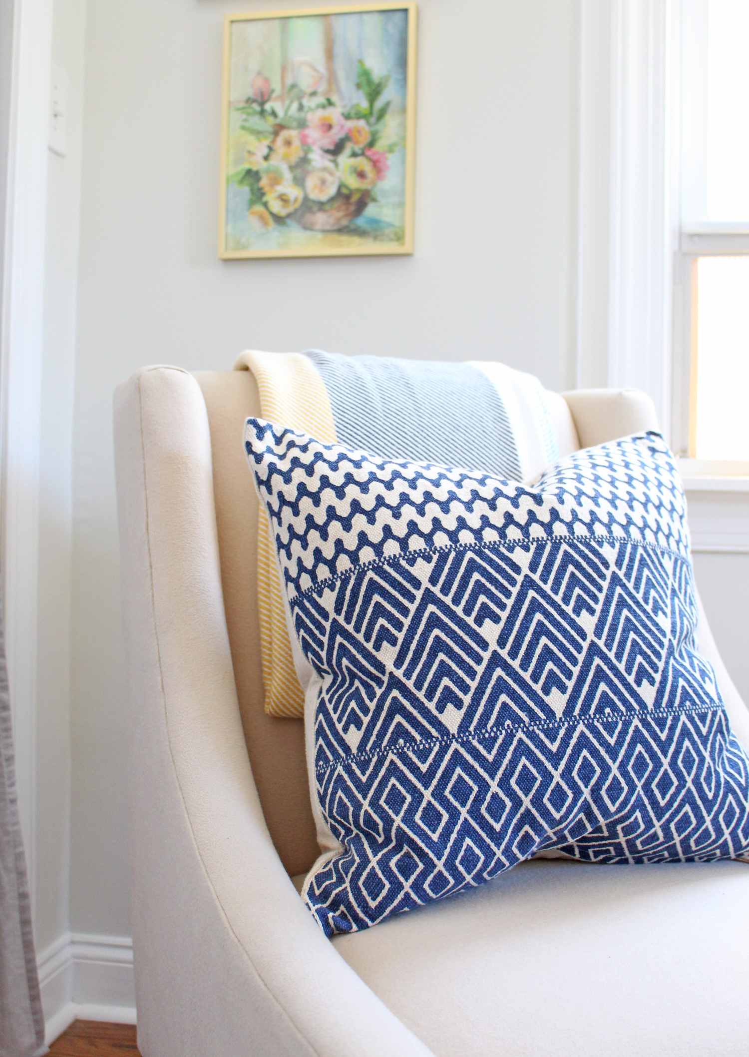 A modern and bright home office gets a bohemian touch in the form of a blue throw pillow.