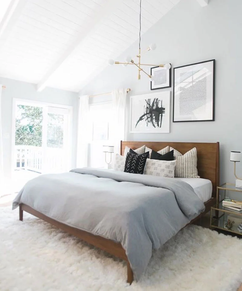 How to decorate around a bed. Option: hang an eclectic collection of art on the wall above the bed. (Design: West Elm) // mid-century bedroom, eclectic bedroom, neutral bedroom, mudcloth pillows
