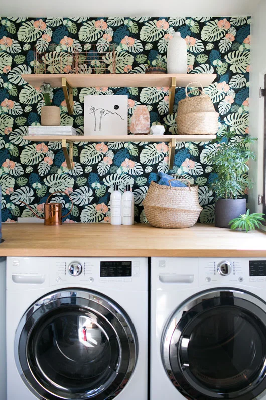 Botanical wallpaper in laundry room with butcher block countertop.