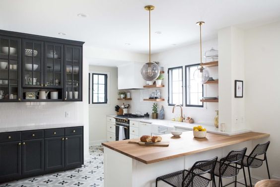 A mix of butcher block and quartz countertops in this kitchen. Learn how and when to mix countertop materials in this blog post! // white and black kitchen