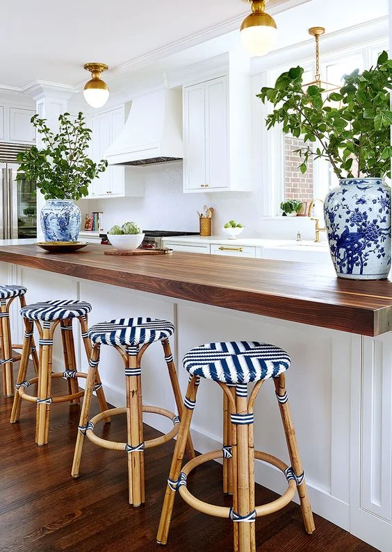 White quartz and thick butcher block countertops make this kitchen special and unique. Mix countertop materials in a kitchen.