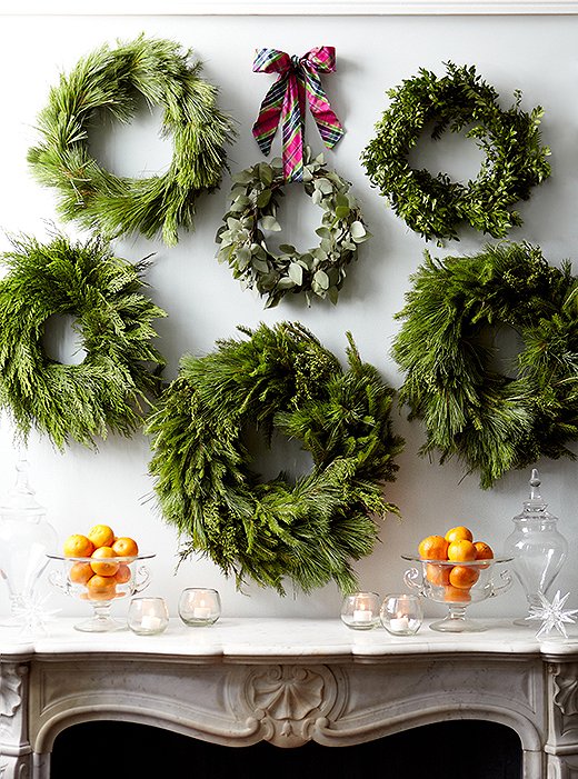 Cluster several wreaths together above a fireplace or on a wall for a big impact when you decorate your home this holiday season. // Christmas wreaths, creative Christmas decor, creative holiday decor ideas, simple holiday decorating