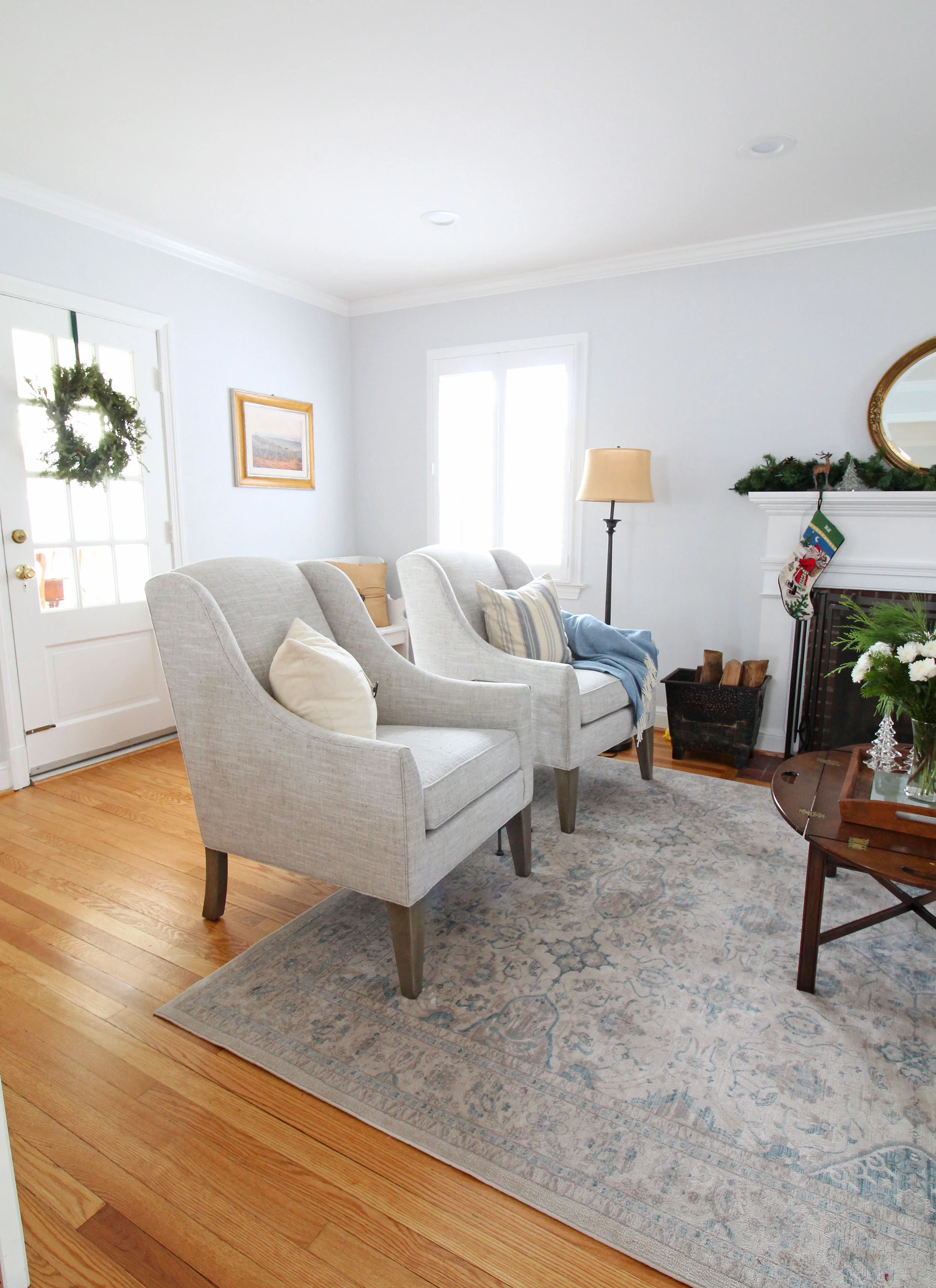 A transitional farmhouse living room. The blue, cream, and gray color scheme feels fresh and clean. This space opens up to the kitchen.
