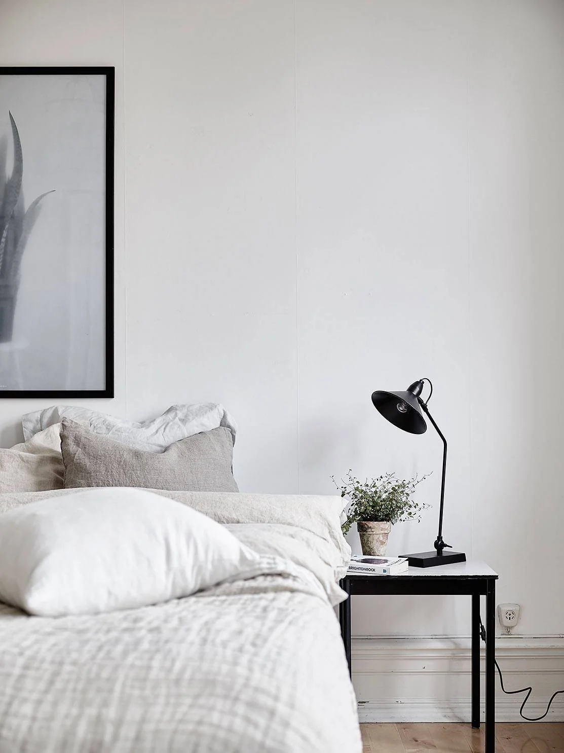 A cozy neutral bedroom with linen bedding and modern furniture. It has a lovely minimalist Scandinavian vibe going on!