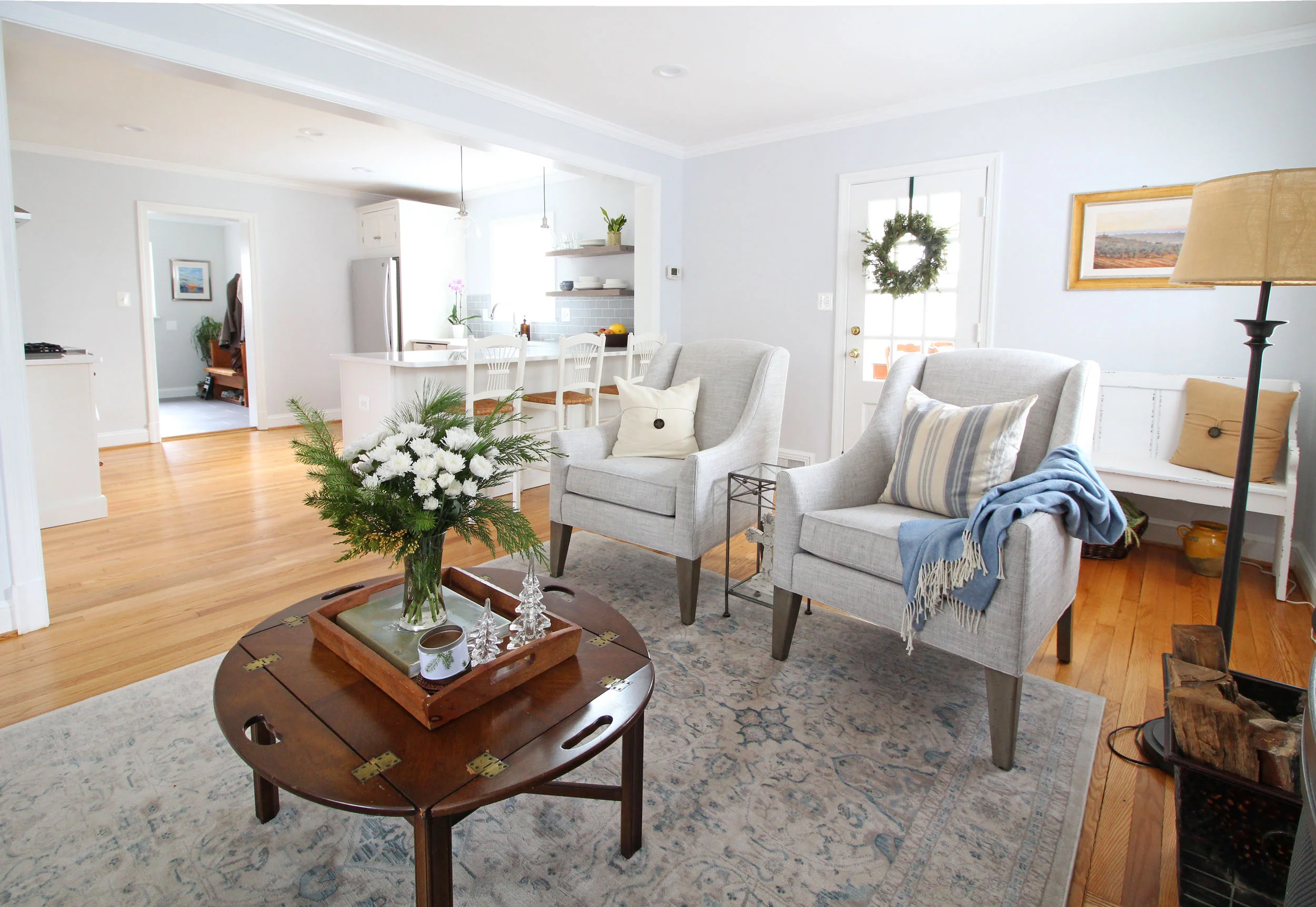 A bright and airy transitional farmhouse living room that opens up into the white kitchen.