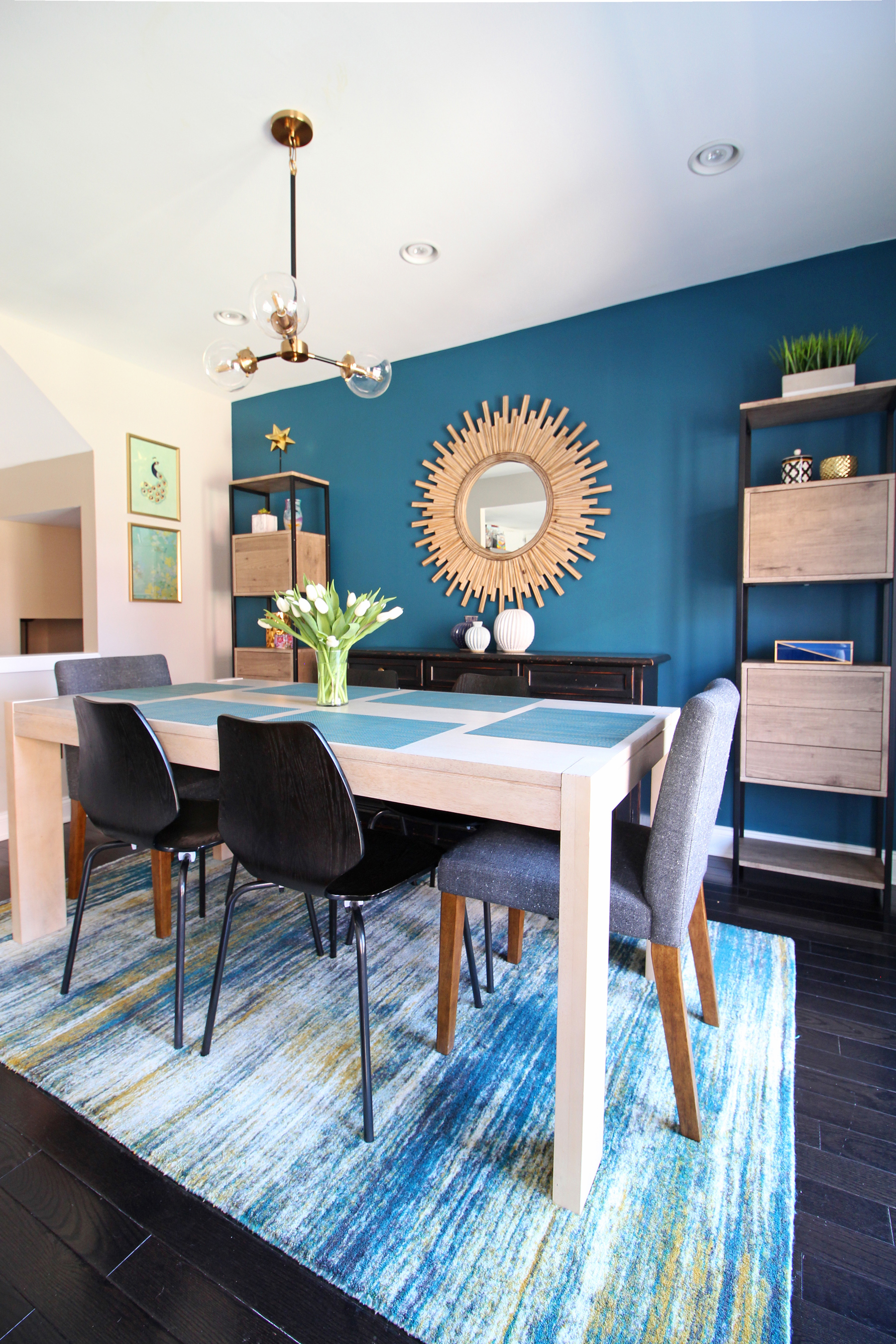 A cozy modern dining room in the heart of Philadelphia. The teal accent wall paired with light wood accents makes for a stunning and functional space for a family of four. Design and photography by Mix & Match Design Company.