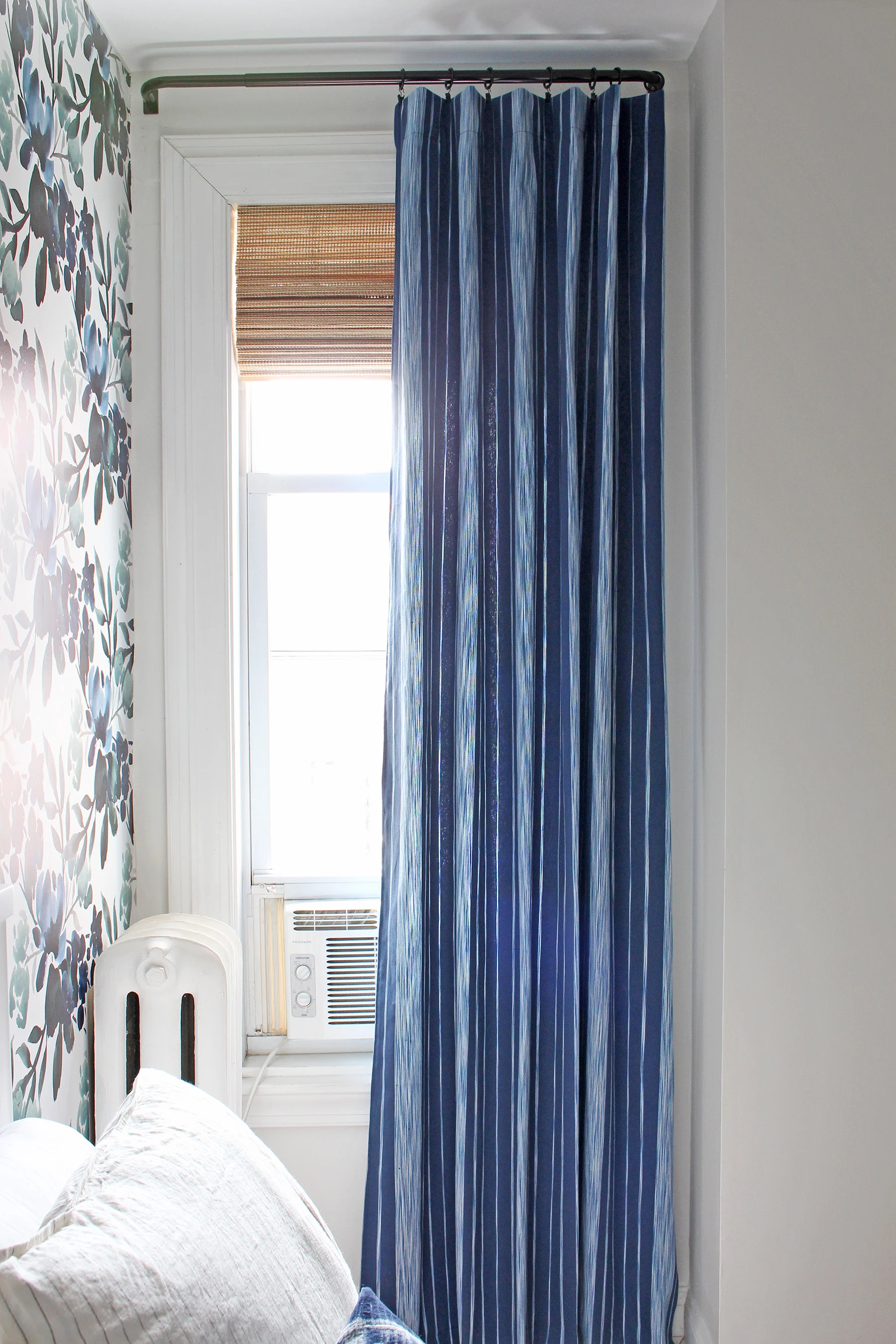 The beautiful curtain fabric is from Calico ("Pizzelle Navy" from the new Vern Yip collection). The blue and white stripe is perfectly paired with a woven roman shade and some bold floral wallpaper in this guest room!