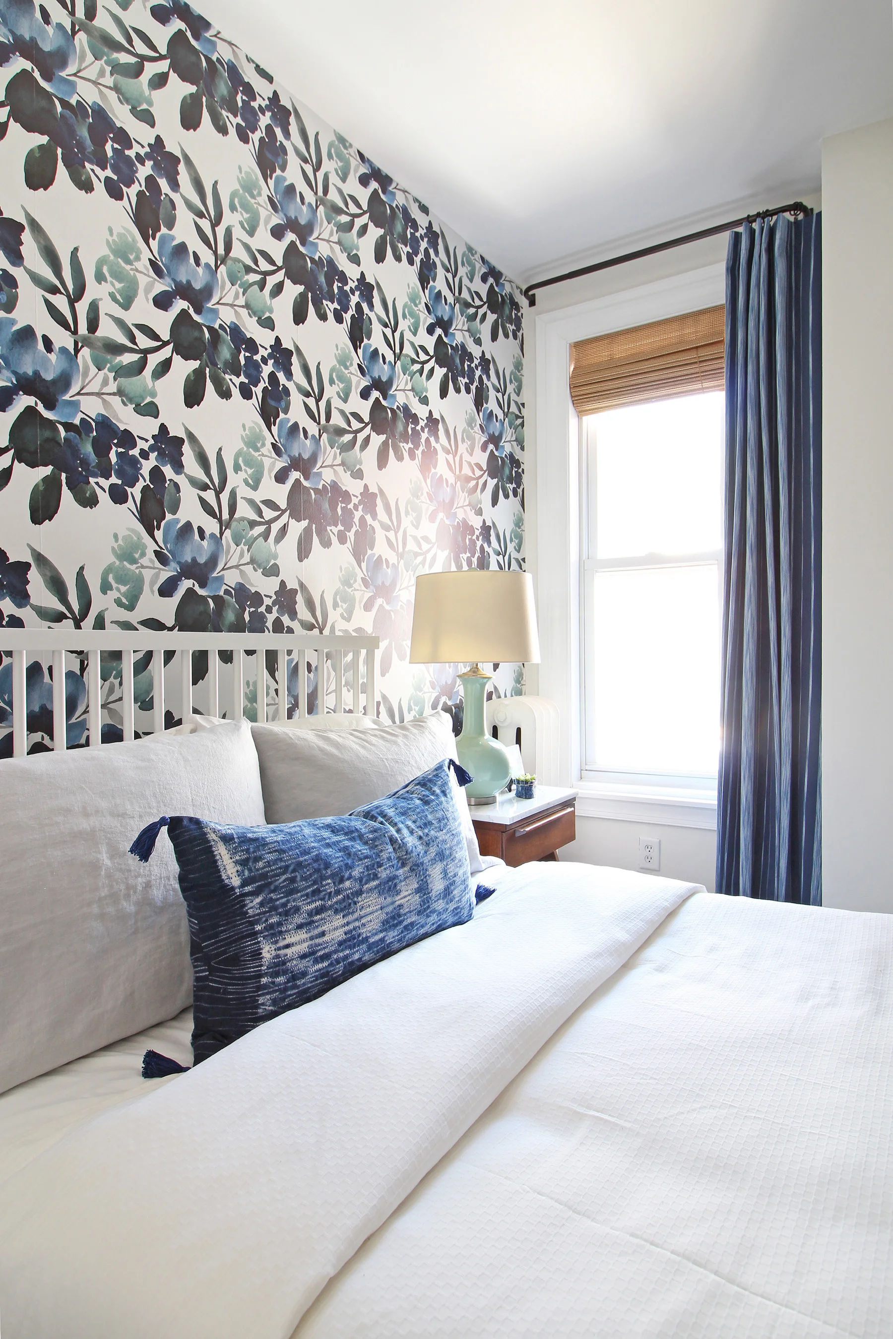 The big One Room Challenge reveal for my eclectic modern farmhouse guest bedroom is up on the blog! Come on over and see the blue-green floral wallpaper, my marble topped vintage nightstands, and my take on modernizing an antique dresser! An indigo lumbar pillow tops off the white bedding. || Design: Mix & Match Design Company
