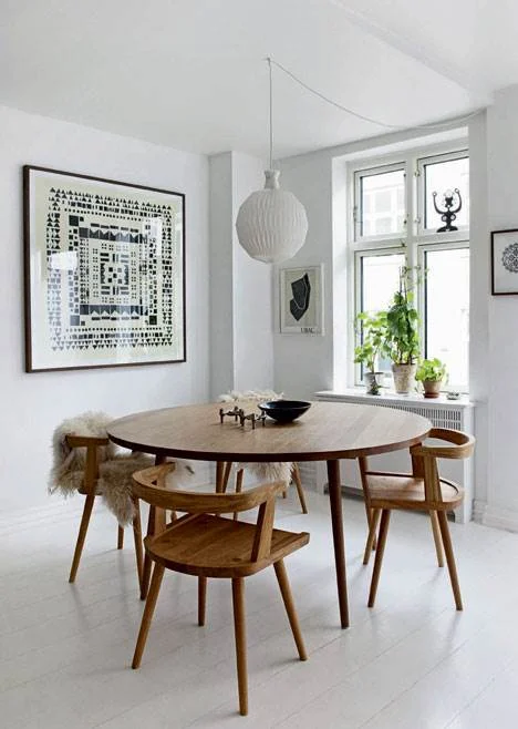 Modern minimalist dining room with wood chairs and a Scandinavian style.