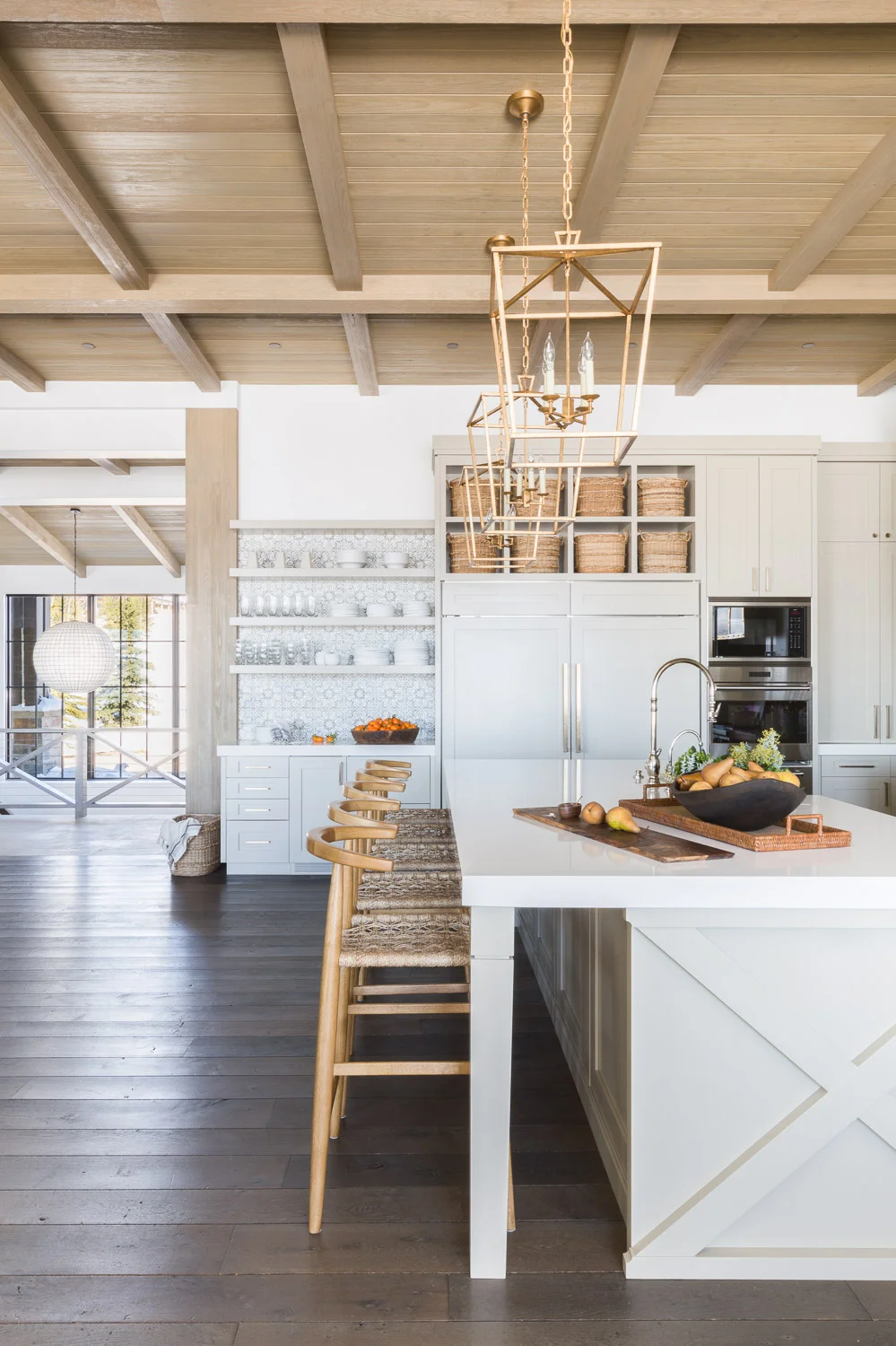 A stunning mountain home kitchen with white cabinets, patterned tile backsplash, and open shelving. // Pros and cons of open shelving