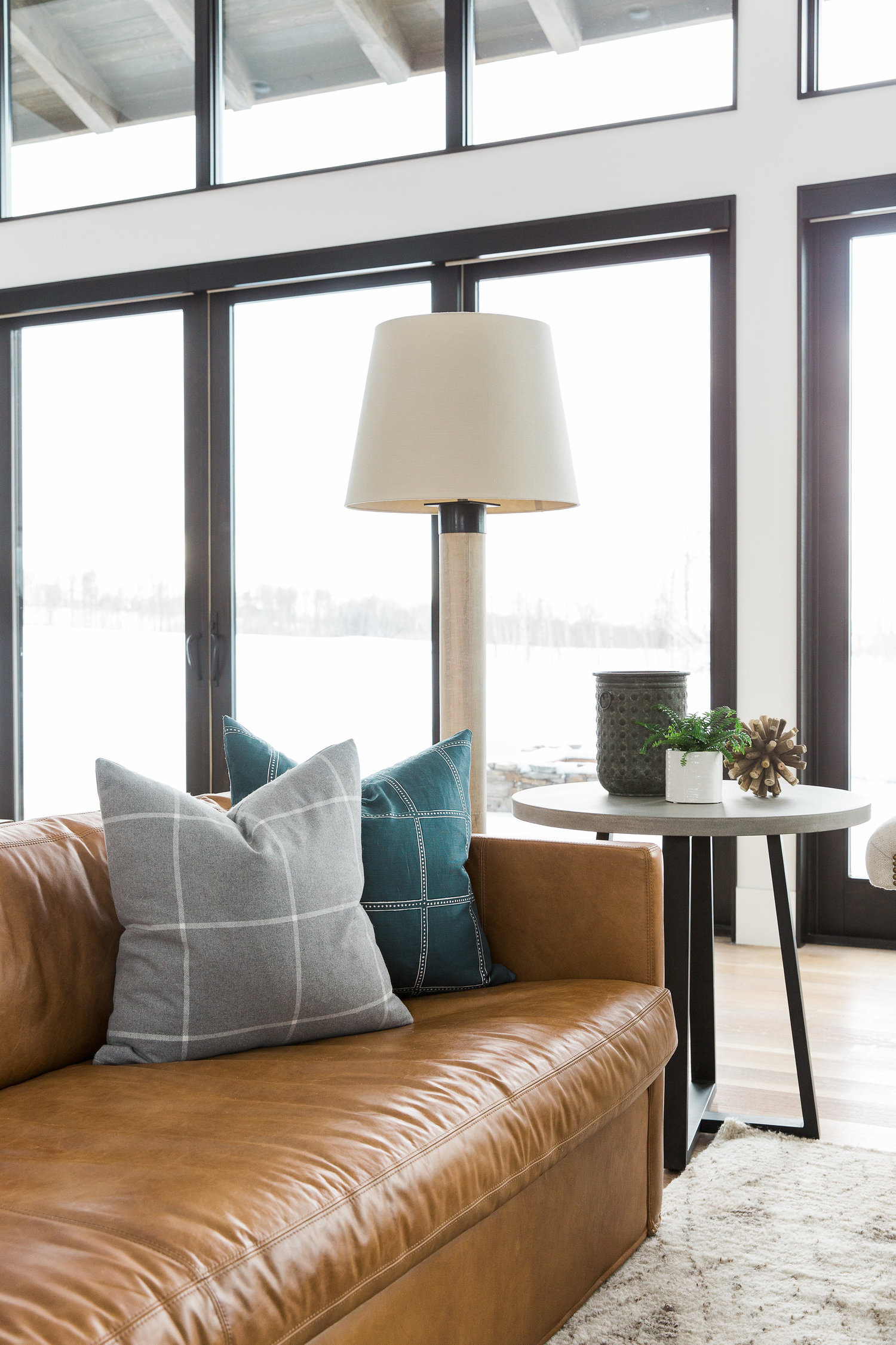 Inspiration for a mountain modern house with a leather sofa, moroccan rug, and plaid pillows.