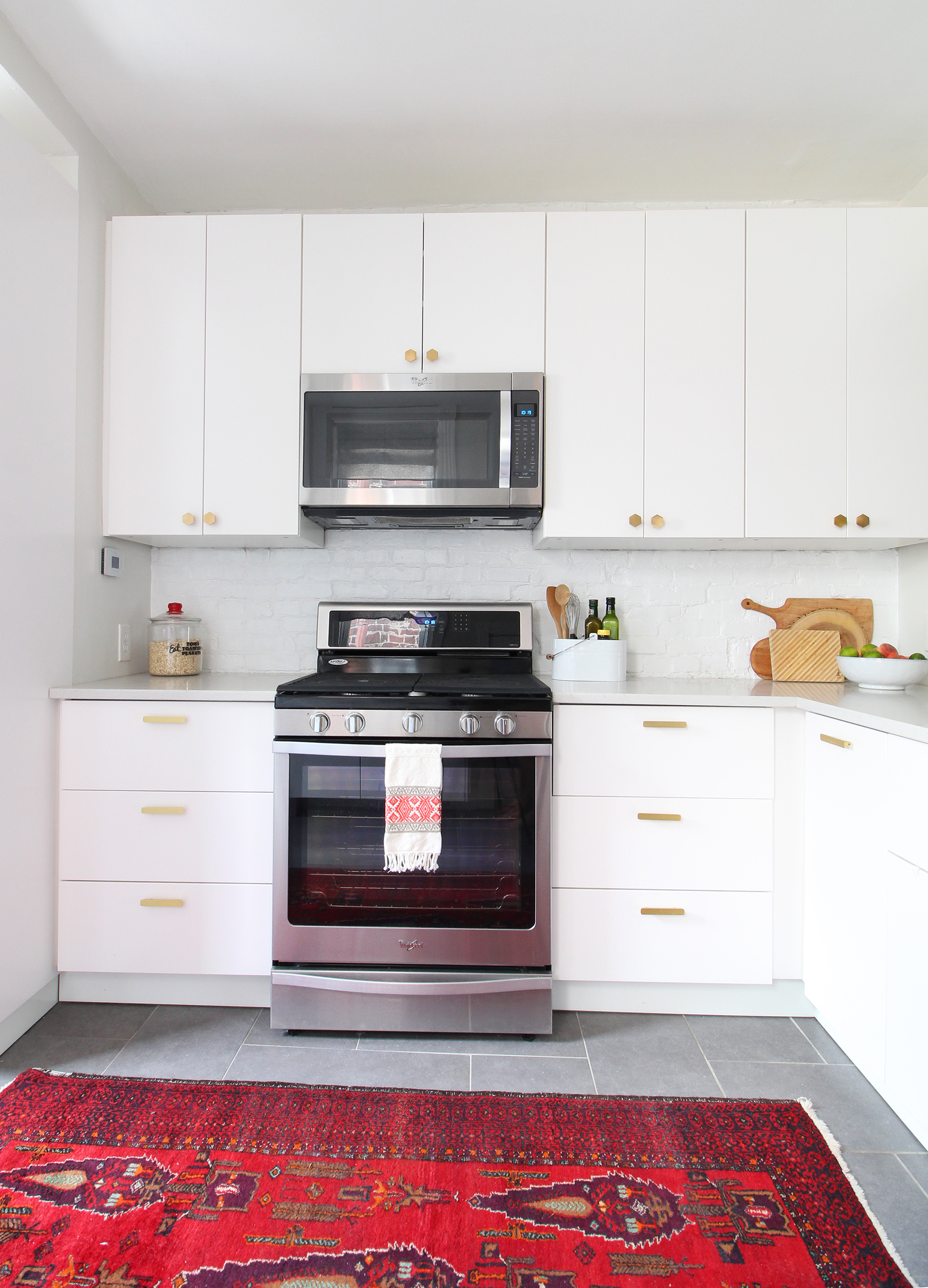 Read my review of our modern white kitchen renovation using IKEA cabinets, Caesarstone countertops, and gray tile floors two years after we renovated. 