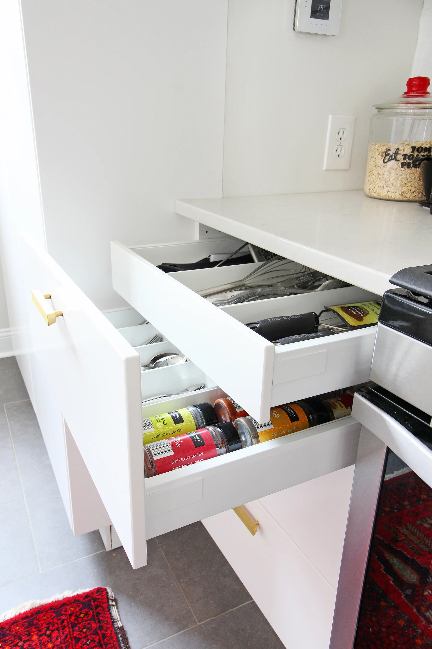 Read my review of our modern white kitchen renovation using IKEA cabinets, Caesarstone countertops, and gray tile floors two years after we renovated. We love the fact that you can customize the interior like this drawer within a drawer!