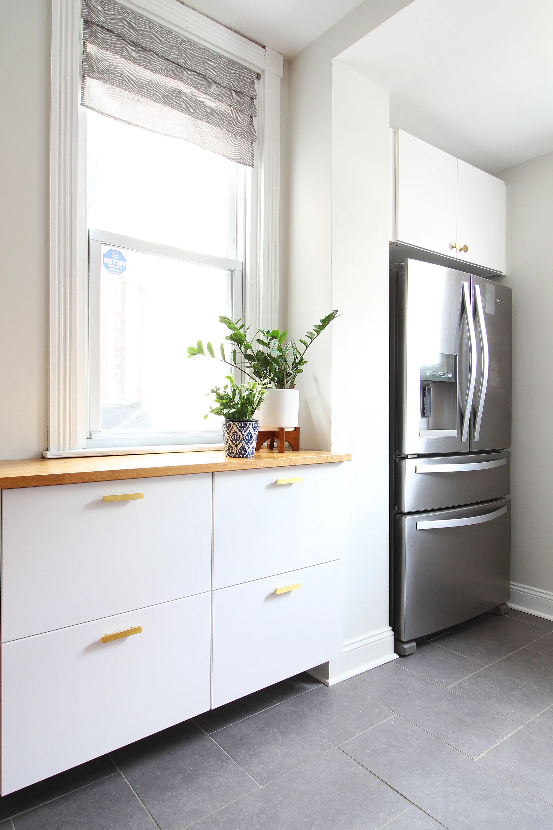 Read my review of our modern white kitchen renovation using IKEA cabinets, Caesarstone countertops, and gray tile floors two years after we renovated. We added radiant heat underneath our tile floors and it is the BEST thing in the winter!