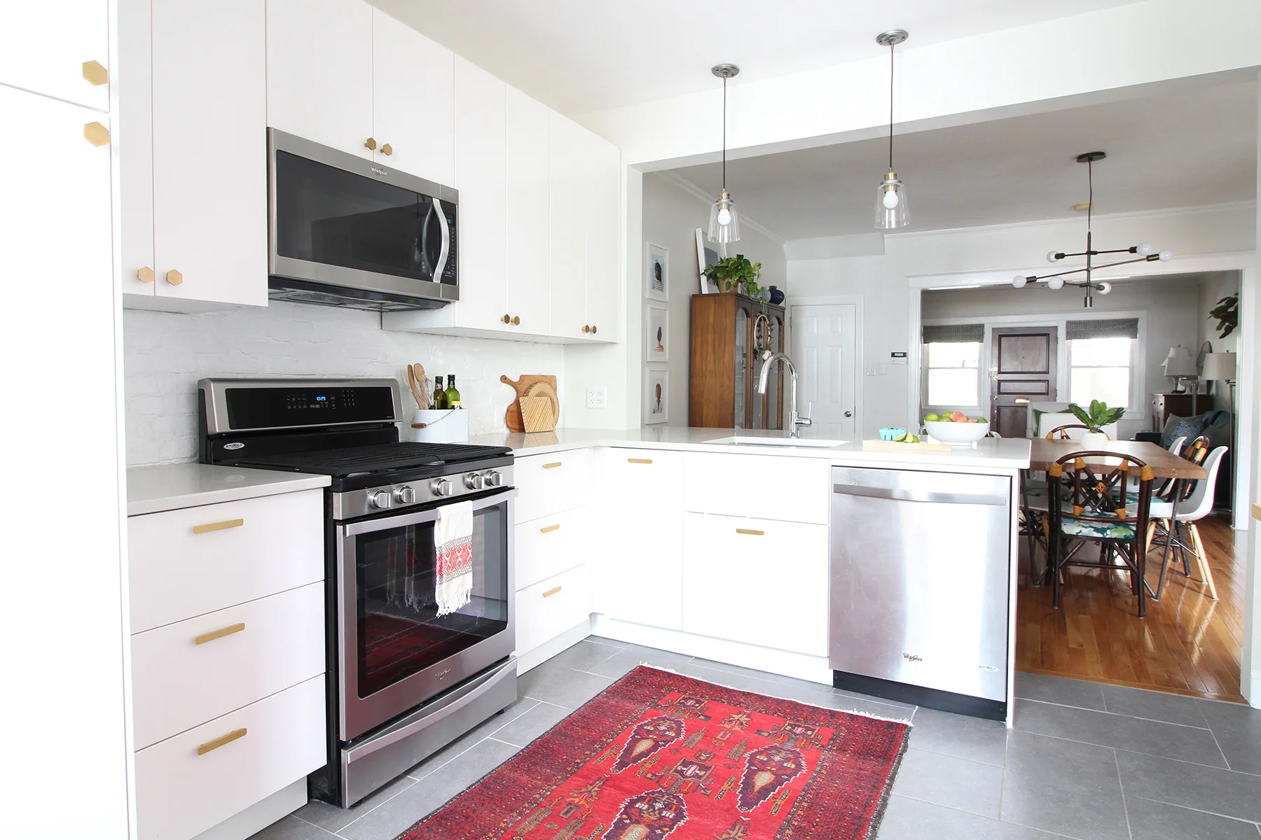 Read my review of our modern white kitchen renovation using IKEA cabinets, Caesarstone countertops, and gray tile floors two years after we renovated. The brass hardware has been a mix of great and "eh" - come on over to read more about it on the blog!