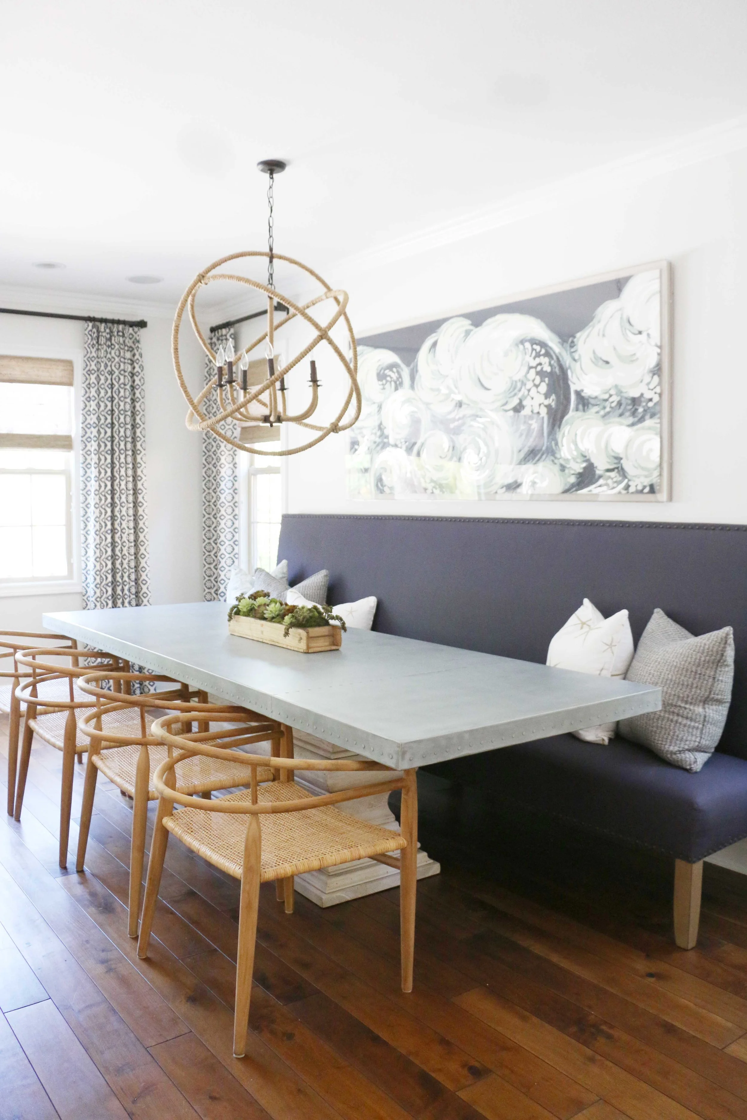 A built-in upholstered dining bench is great for extra seating and maximizes space in this coastal home. For more ideas on how to use benches in your home, head to this blog post!