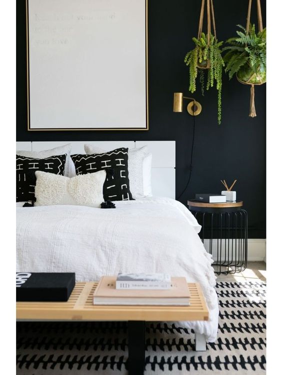 Love the look of this black and white bedroom with a modern eclectic style. Those hanging plants in the corner and black mudcloth pillows are great details. See how you can get a similar look in your own home over on the blog!