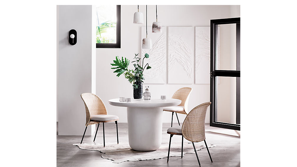 Beautiful cane and rattan dining chairs in a modern dining room with the white pedestal table.Chairs from