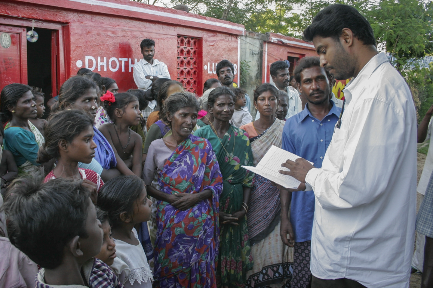The Rev. A. Sahaya Philomin Raj, S.J., an advocate or lawyer, passes out Tamil translations of the government’s guidelines for obtaining tsunami aid in the Dalit village of Yerum Salai Graman, in southeast India. The government had published the guidelines in English, which the Jesuits then translated.