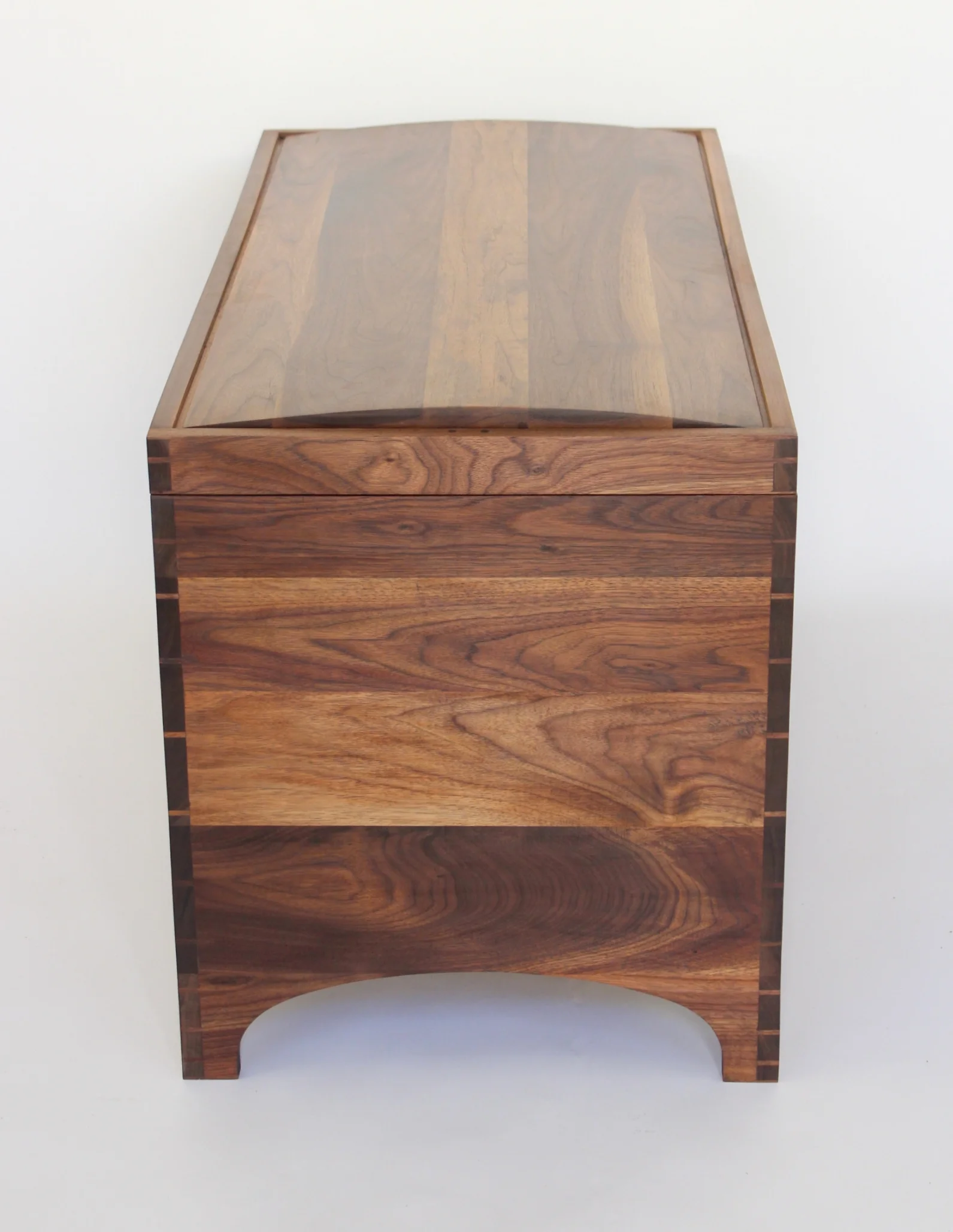 The side profile of the chest shows the graduated dovetails, as well as the arc of the panel top and the leg cutaway