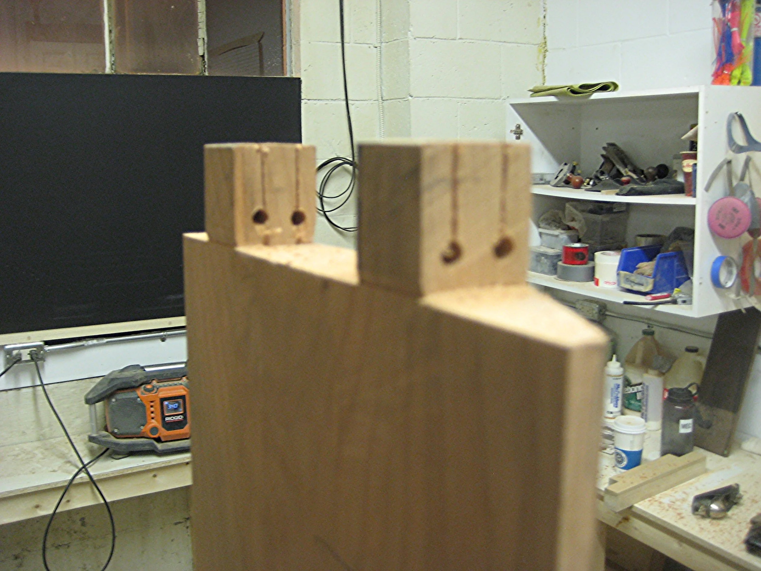 The tenons being prepped for wedges with saw cuts and holes drilled so that the stock resists splitting.