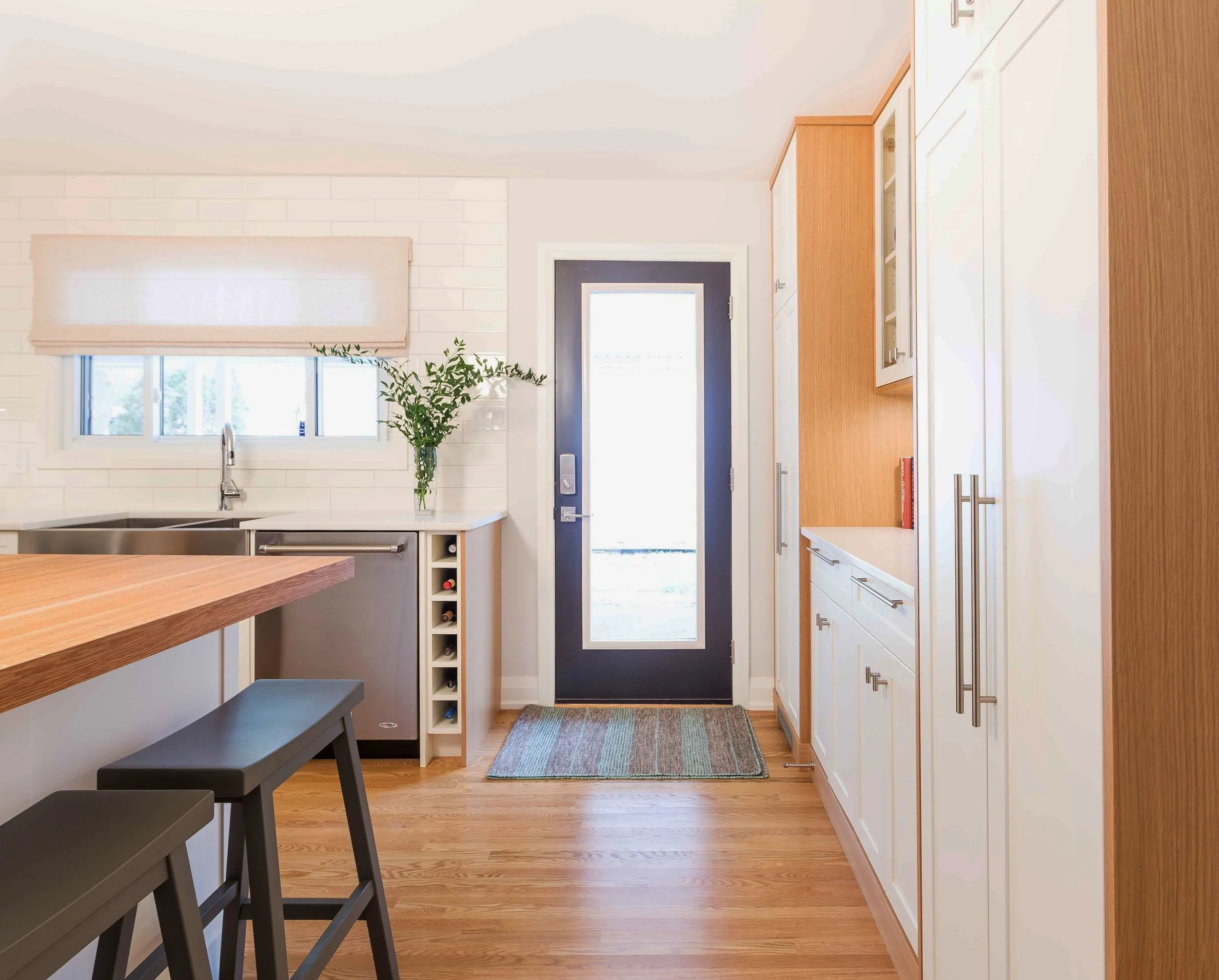 The cabinetry to the right of the side entrance covers many necessities: coat storage, bar glasses and liquor storage and a full height pantry with roll out drawers.