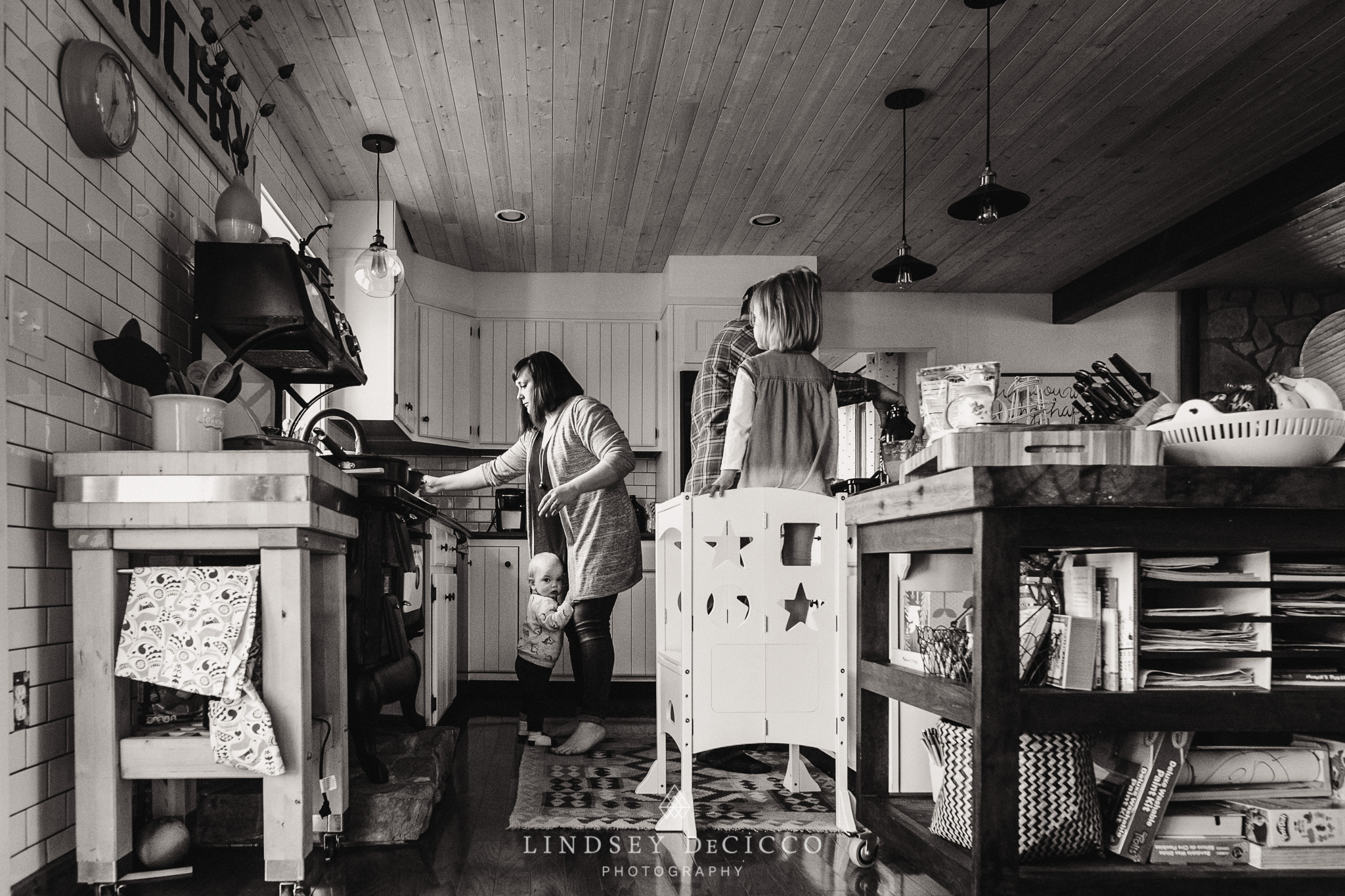 toddler holding mom's legs in the kitchen