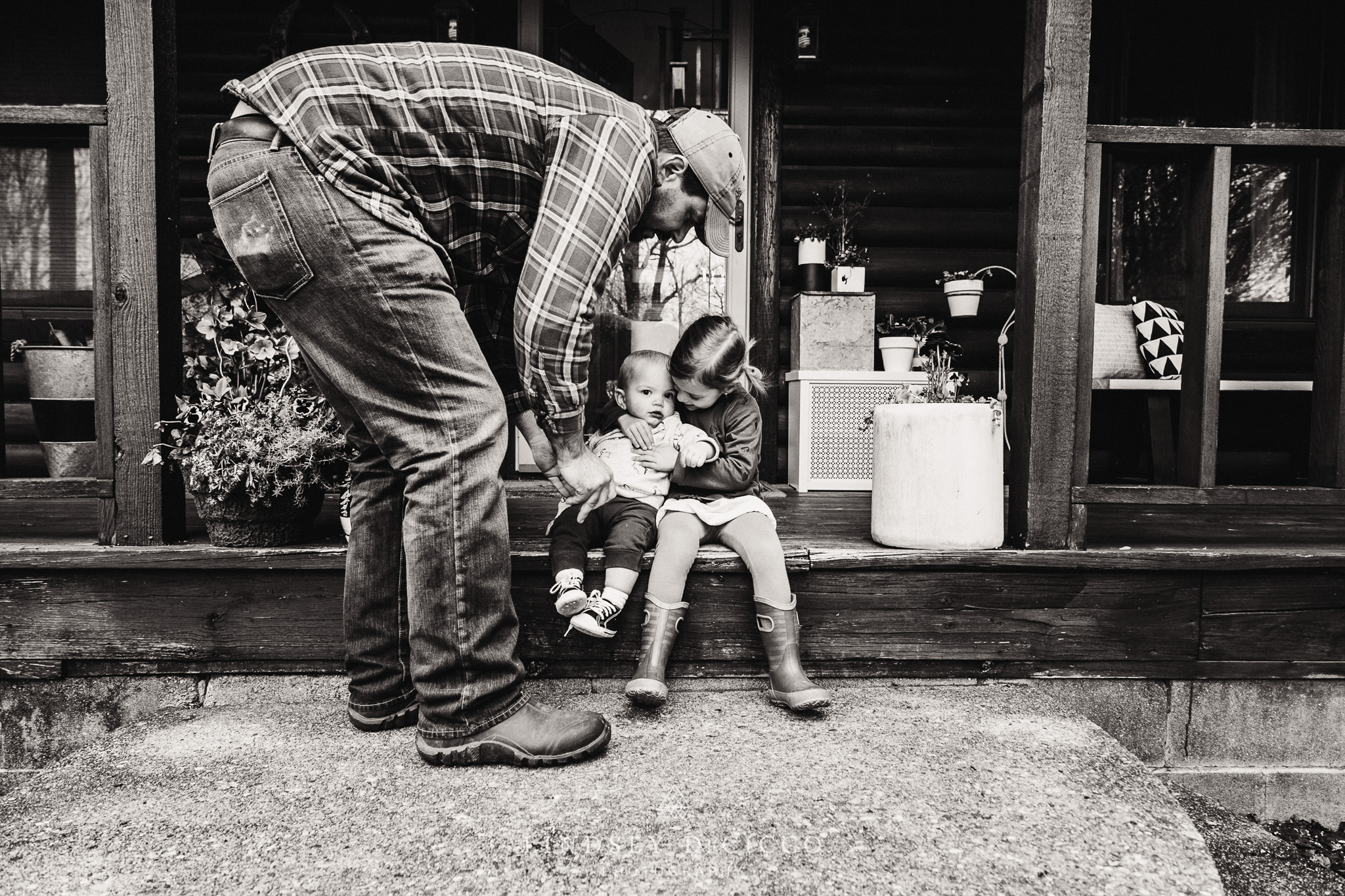 son and daughter with dad on front porch