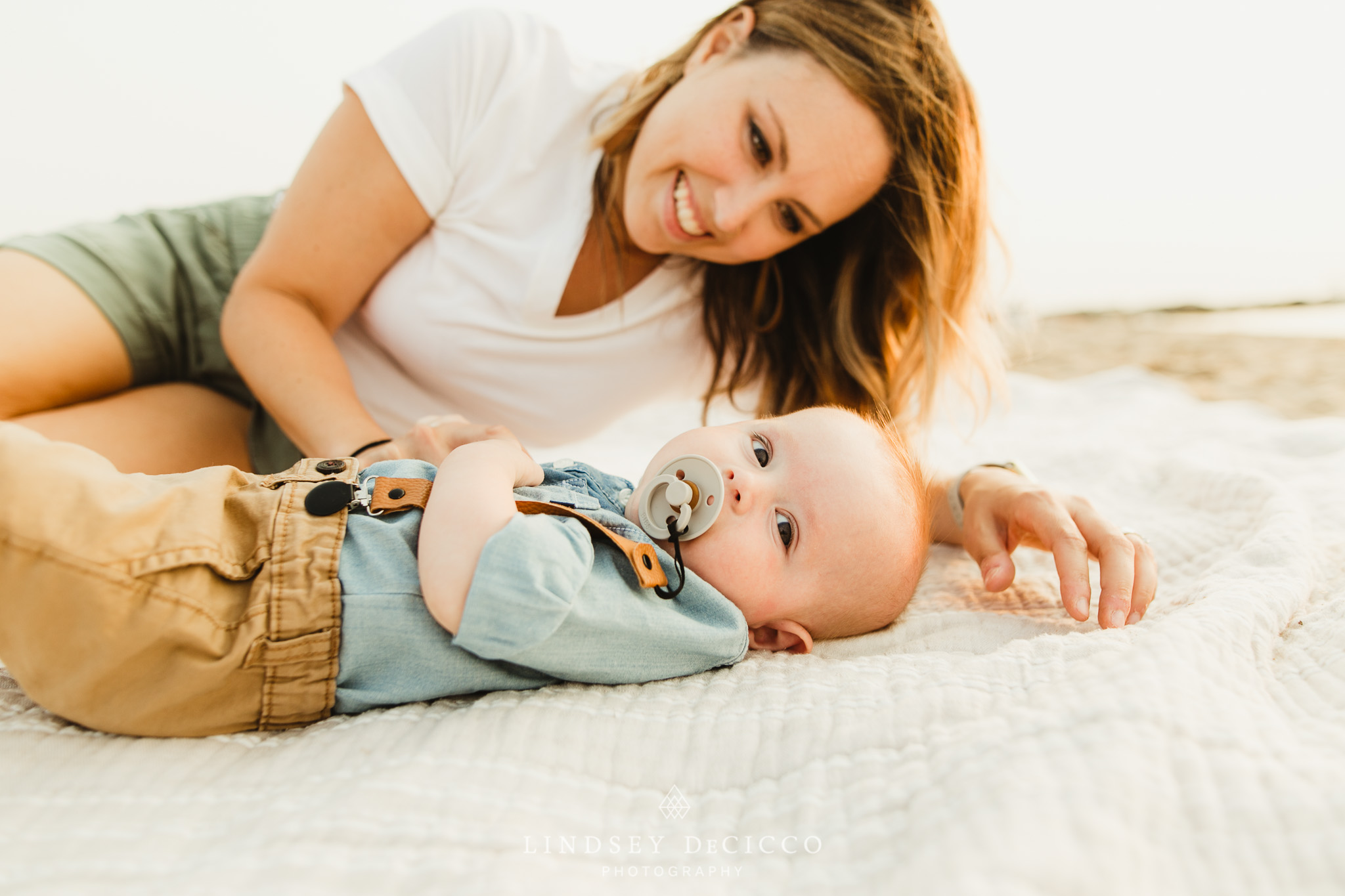 mother comforting baby on beach