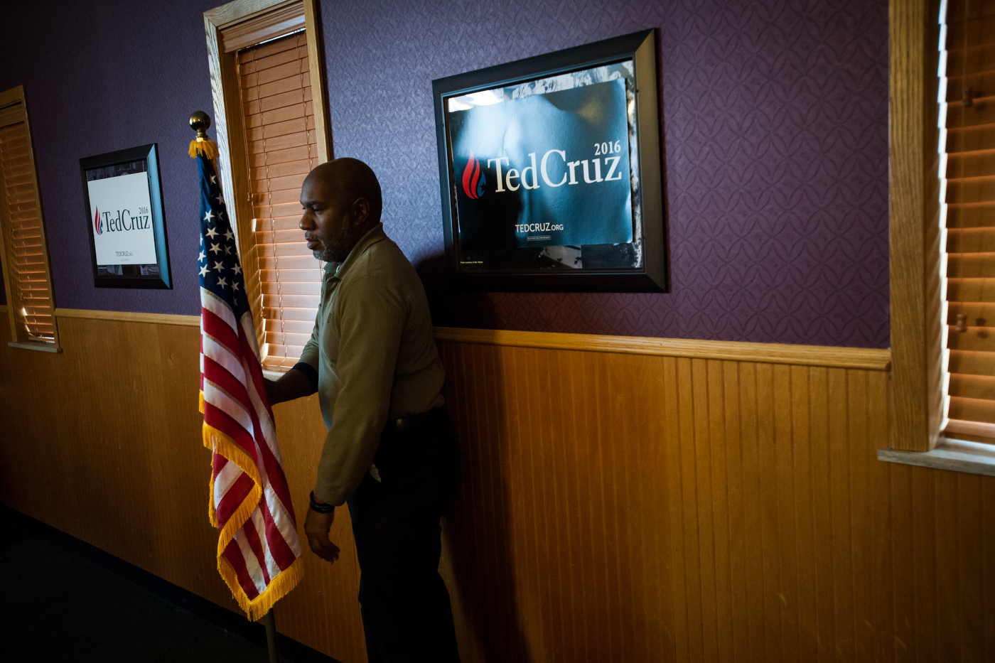  A man adjusts a flag ahead of Republican U.S. presidential candidate Ted Cruz' campaign stop at Godfather's Pizza in Spirit Lake, Iowa on January 6, 2016.  