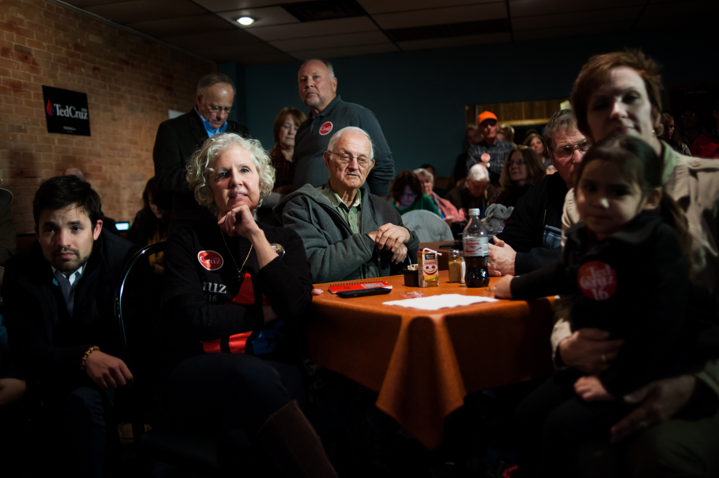  Supporters listen as Republican U.S. presidential candidate Ted Cruz does a live television interview ahead of his campaign stop at Prime Time Restaurant in Guthrie Center, Iowa on January 4, 2016. 