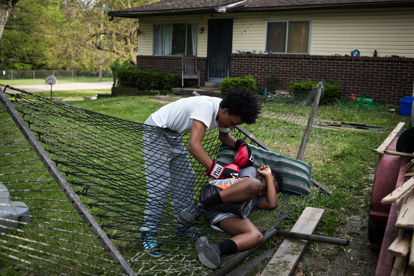 Courtney Smith, left, boxes his cousin Michael Hancock outside Hancock's stepfather's home. Eric Dillon, Hancock's stepfather and Smith's uncle says he was one of the few kids he grew up with that stayed out of jail and uses his experiences to be a strong influence on his son, step-son, and nephew.