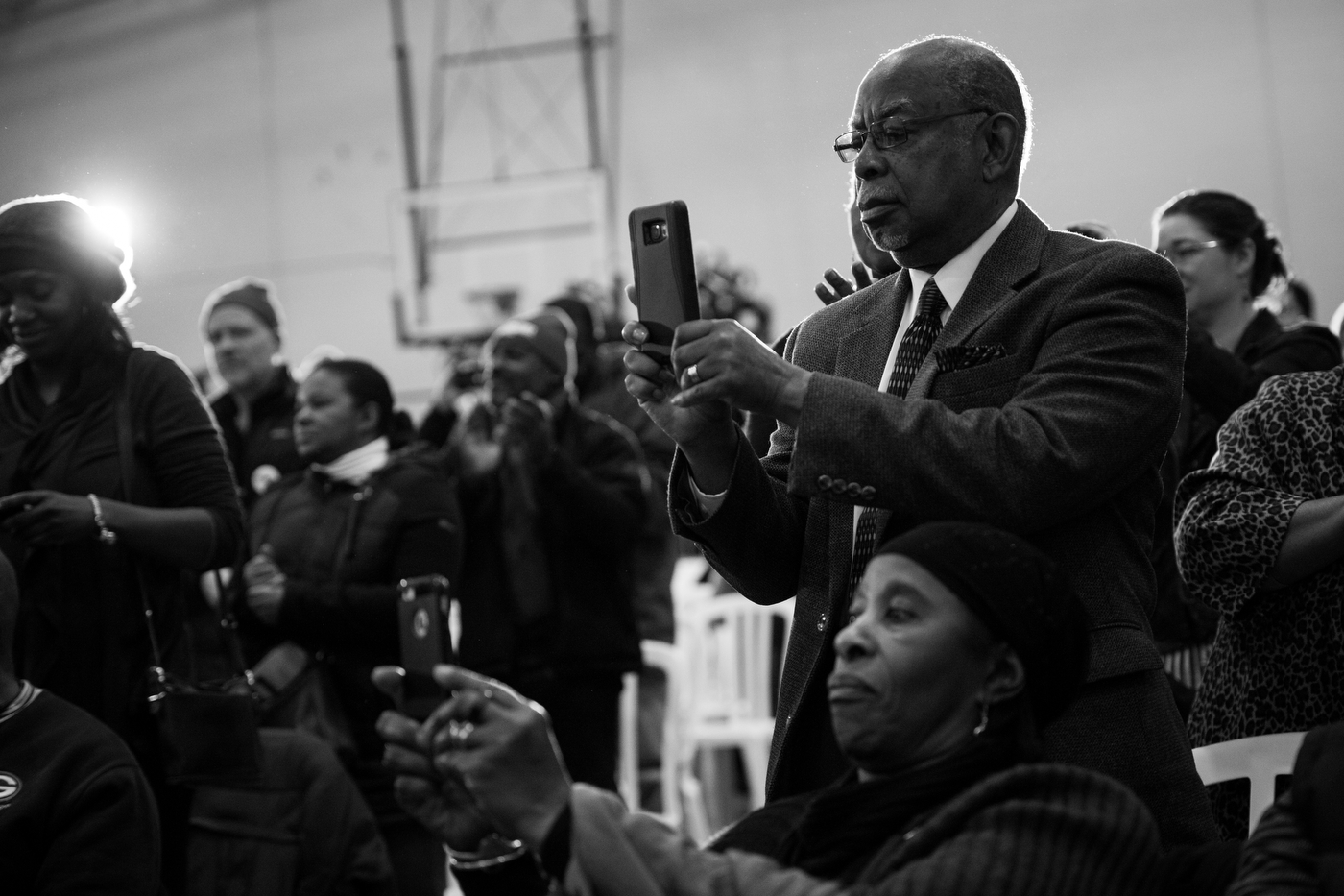  People photograph as Democratic presidential candidate Bernie Sanders takes the stage at an African-American Community Conversation town hall event in Milwaukee, Wisconsin on April 2. Sanders struggled behind opponent Hillary Clinton to garner the s