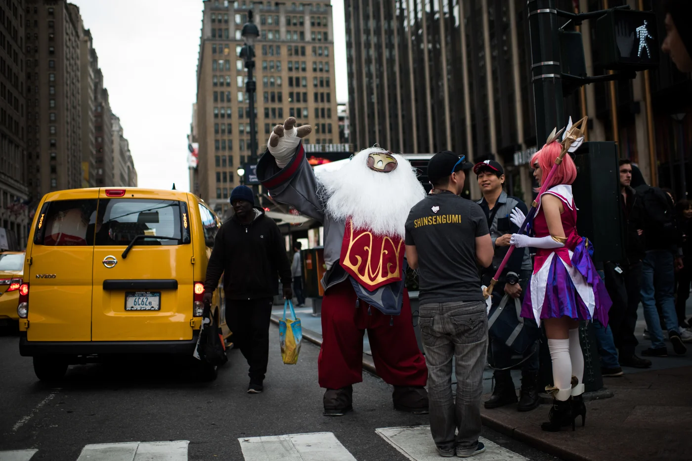 A League of Legends cosplayer dressed as the champion Bard poses for a photo, accidentally hailing a cab on the street outside Penn Station in New York.