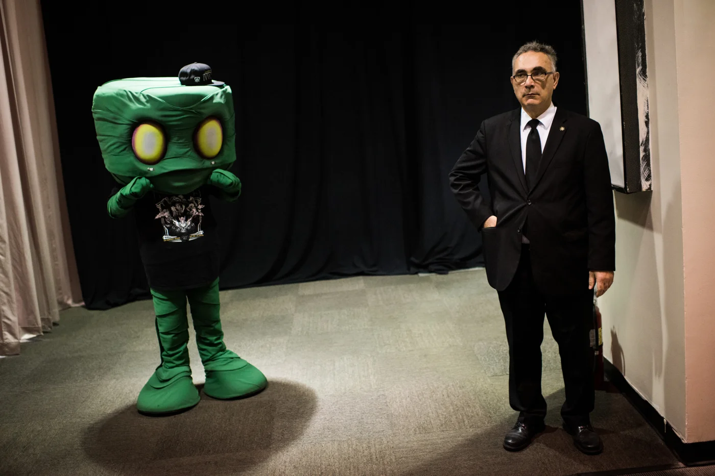 A security guard stands next to a person cosplaying as Amumu, a champion from League of Legends.