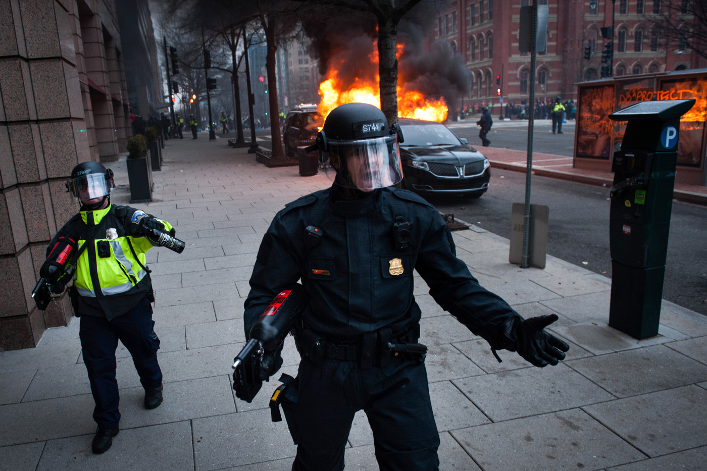 Washington Metro Police use water canons and pepper spray to move protestors away from a burning limousine, lit on fire by ANTIFA protesters, on the day of the President Donald Trump's inauguration in Washington, D.C., on January 20, 2017.