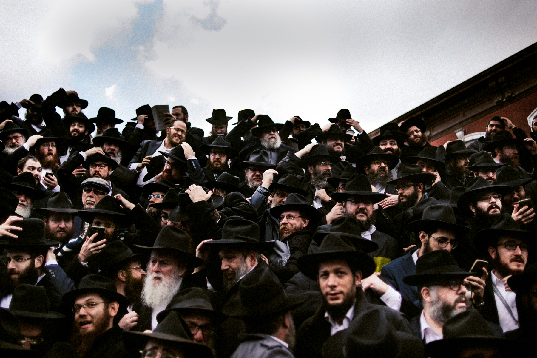  Chabad-Lubavitch rabbis hold on to their hats in a gust of wind as they gather for a group photo in front of the movement's headquarters in the Crown Heights neighborhood of Brooklyn, NY in 2017. 